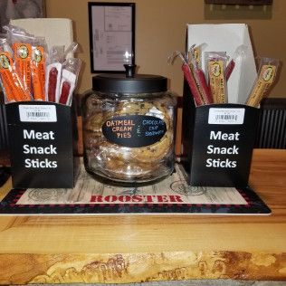 A table with a jar of meat snack sticks and a jar of oatmeal cream pies.