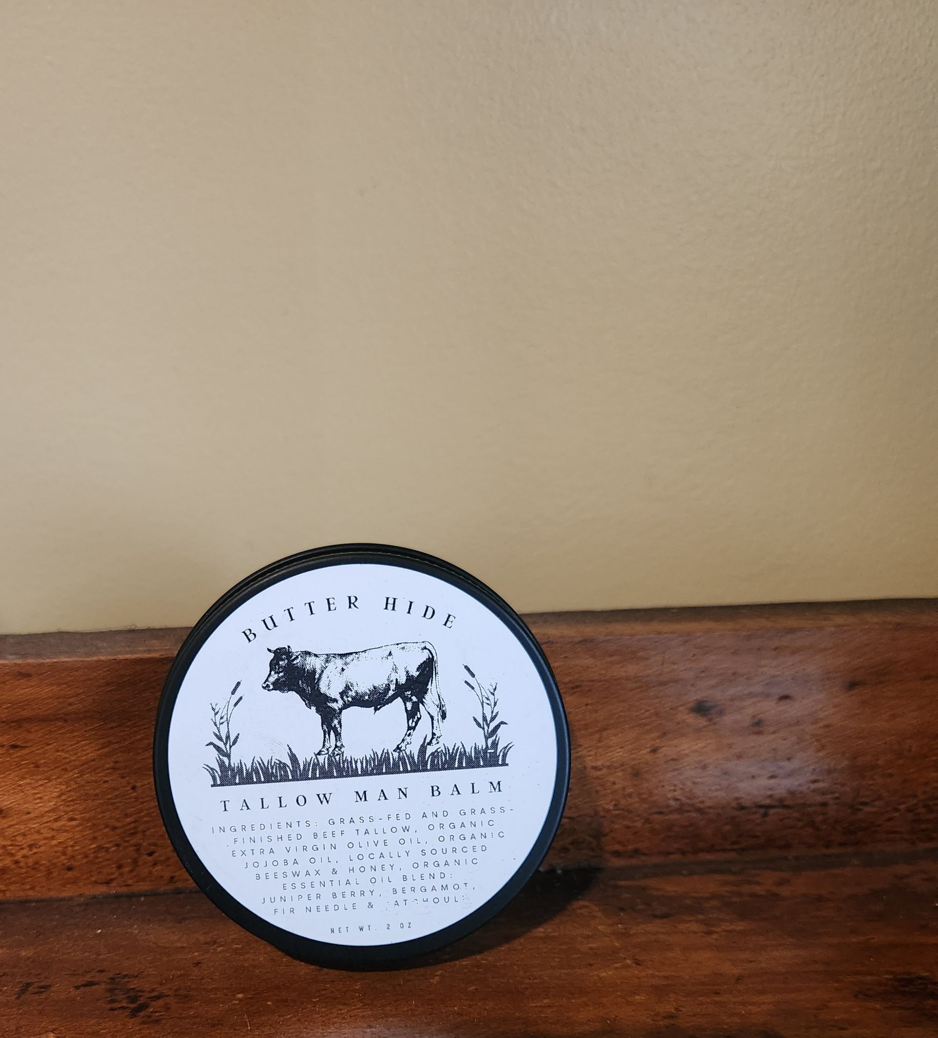 A round container with a cow on it that says follow wax balm
