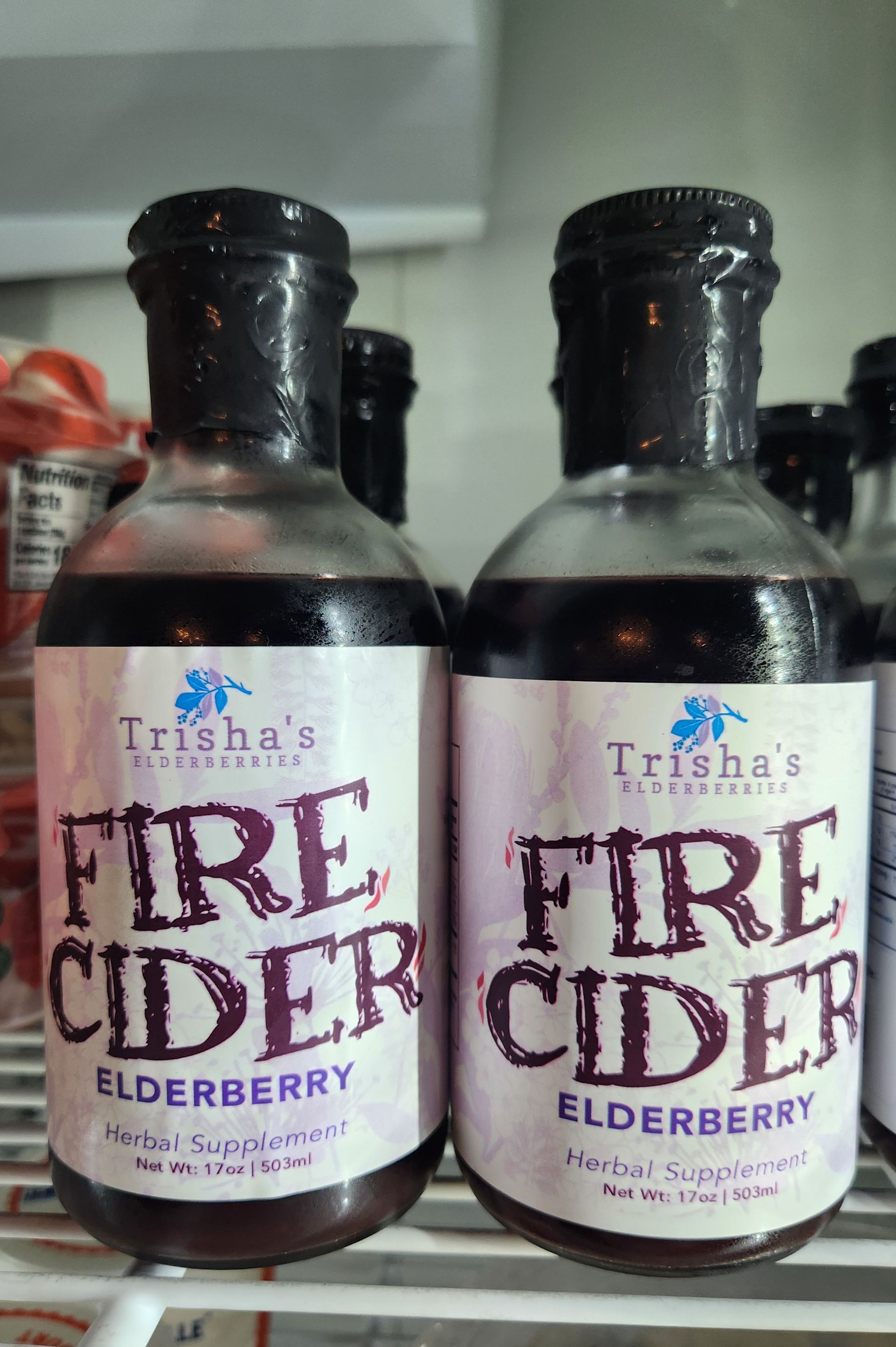 Two bottles of fire cider elderberry on a shelf