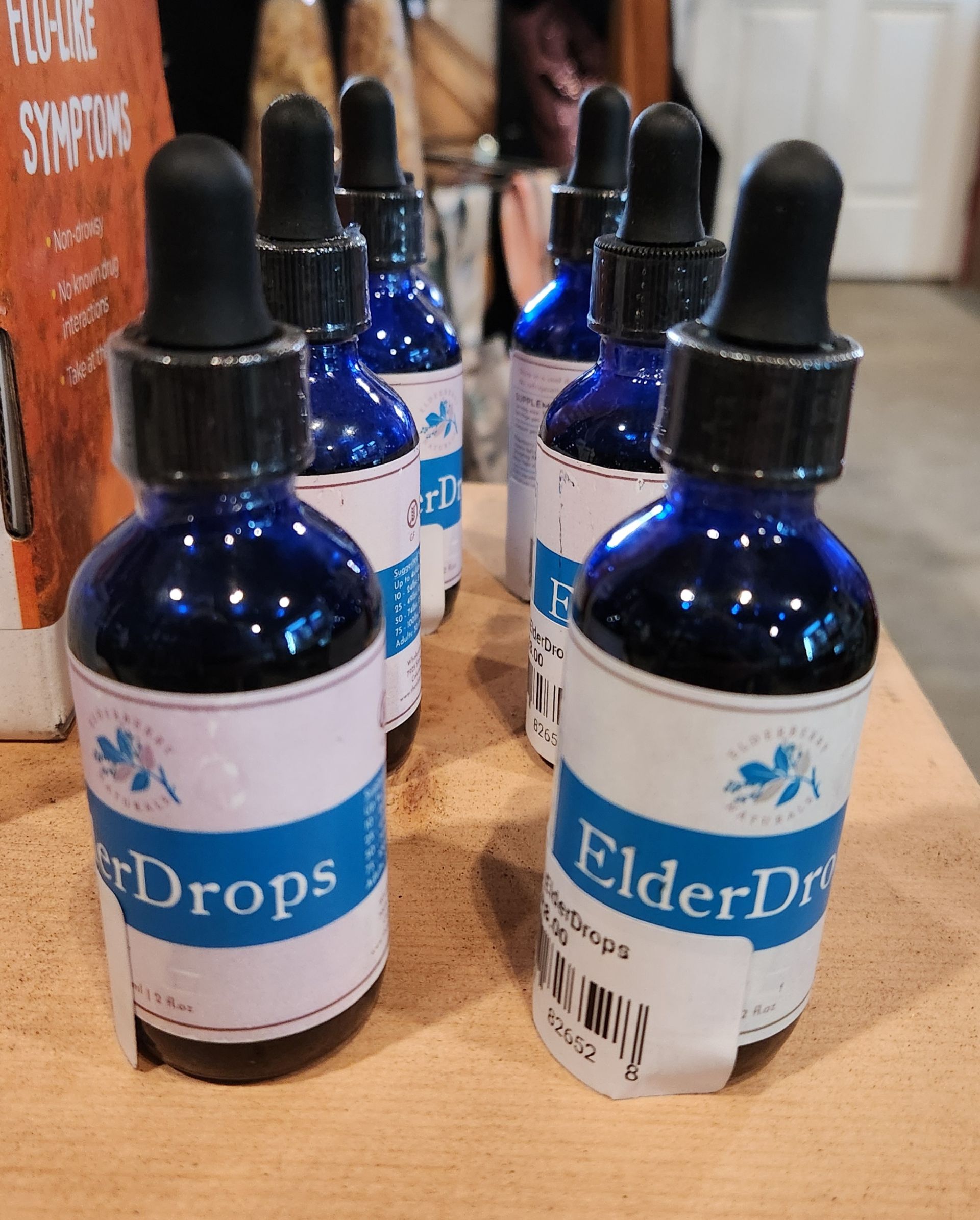Several bottles of elder drops are lined up on a table