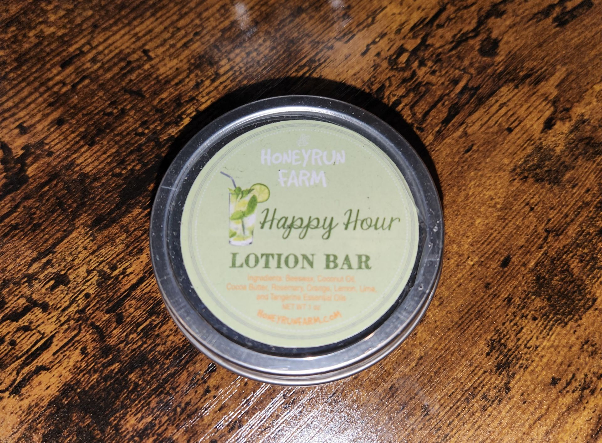A happy hour lotion bar is sitting on a wooden table.
