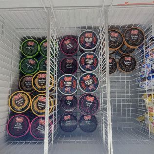 A freezer filled with lots of ice cream cups.