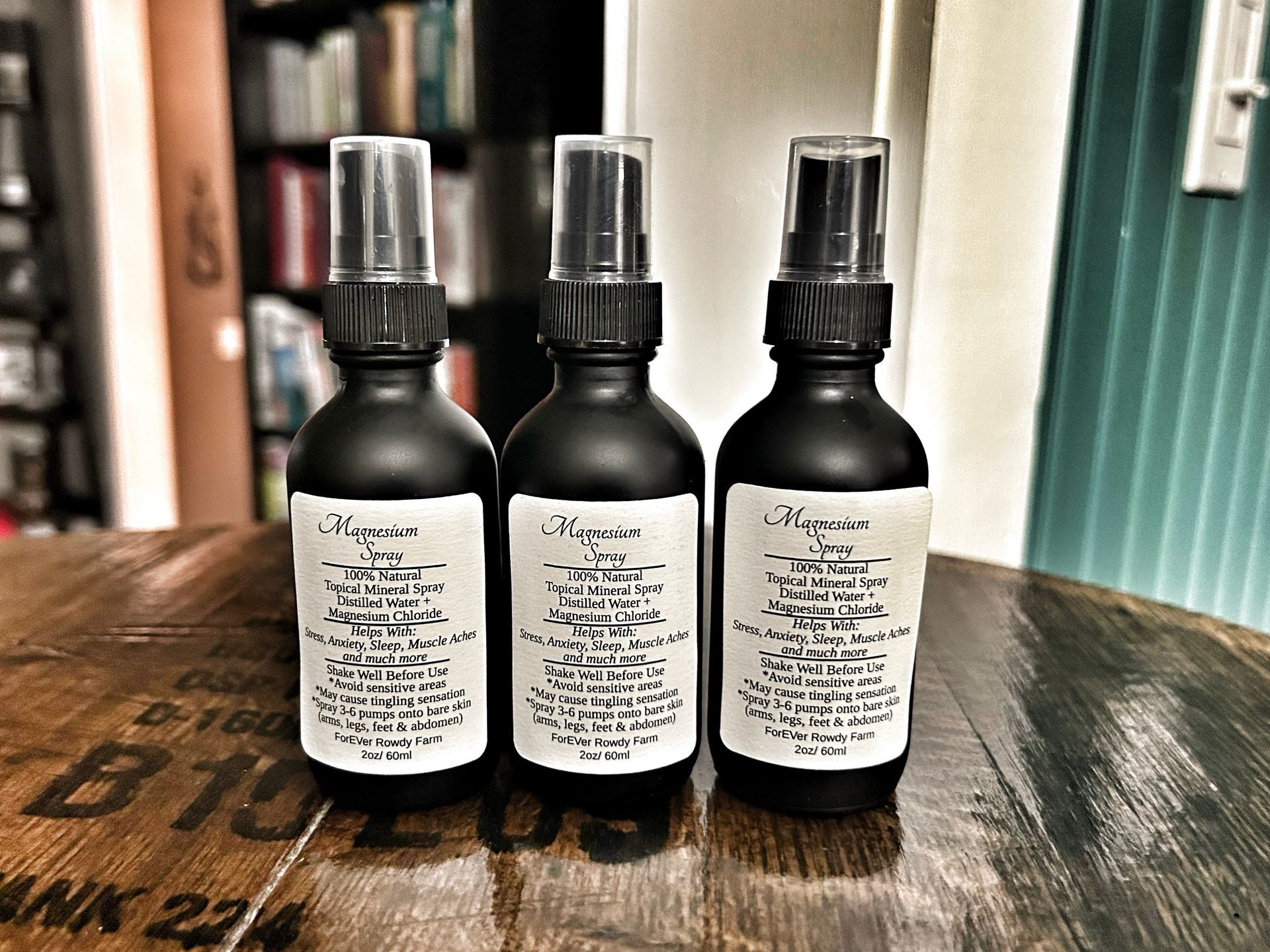 Three spray bottles are sitting on a wooden table.