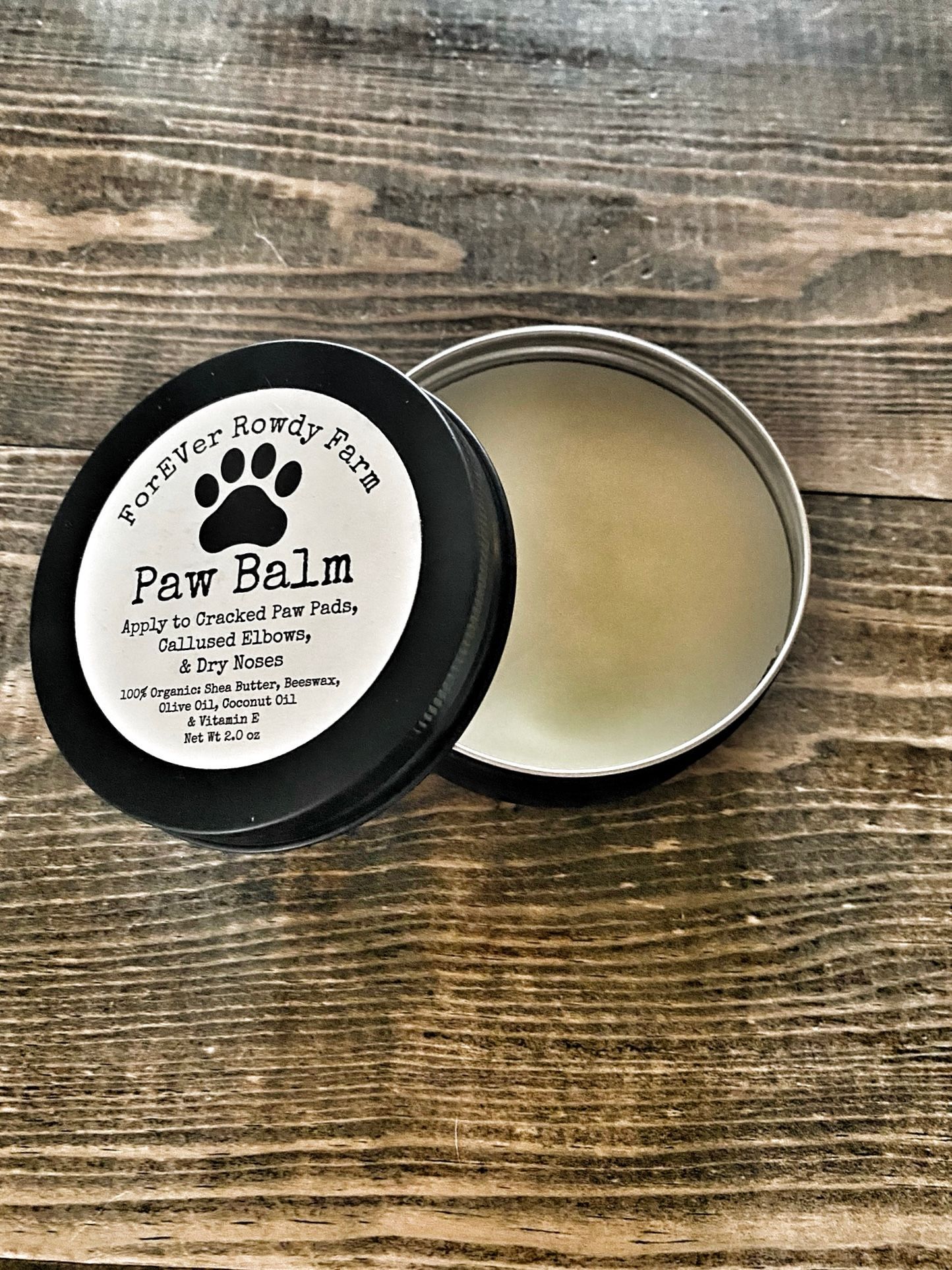 A can of paw balm is sitting on a wooden table.