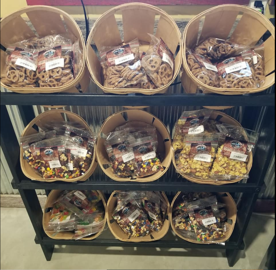 A shelf filled with baskets of nuts and pretzels