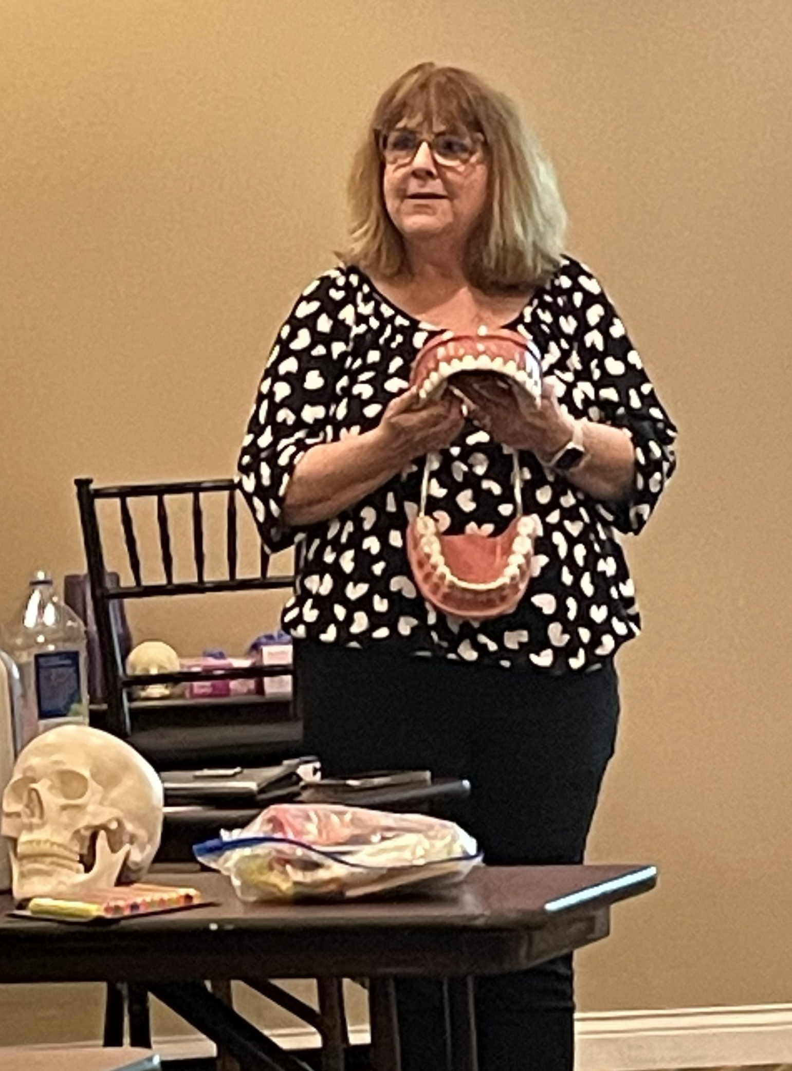 Mary Billings demonstrating with a large model of a mouth and teeth