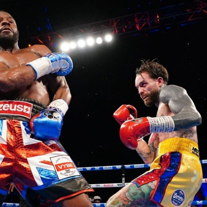 Boxers in ring; one throws a punch, the other guards. Union Jack shorts and tattoos are visible.