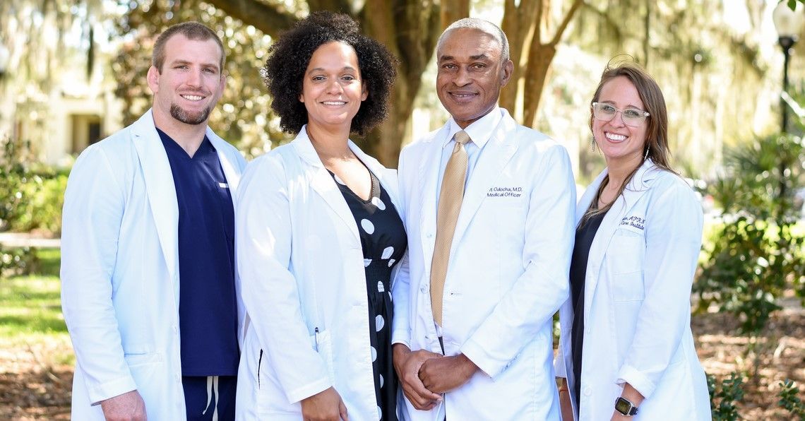 Four doctors in white coats standing outside, likely healthcare professionals.
