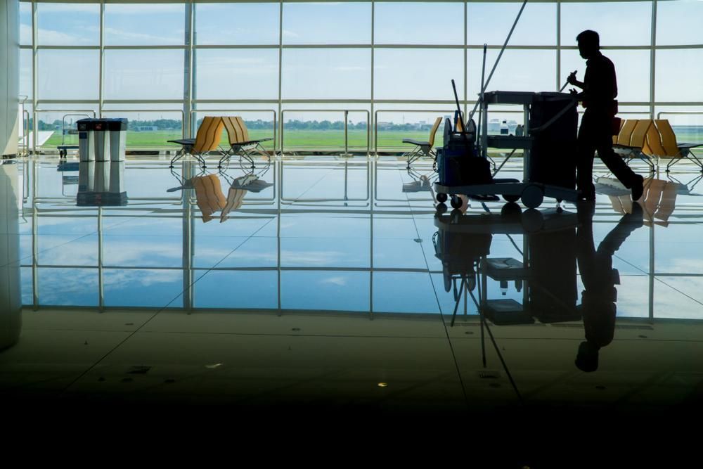 A Man Is Mopping the Floor in An Airport Waiting Area — KJ's Elite Cleaning Services Newcastle in East Maitland, NSW