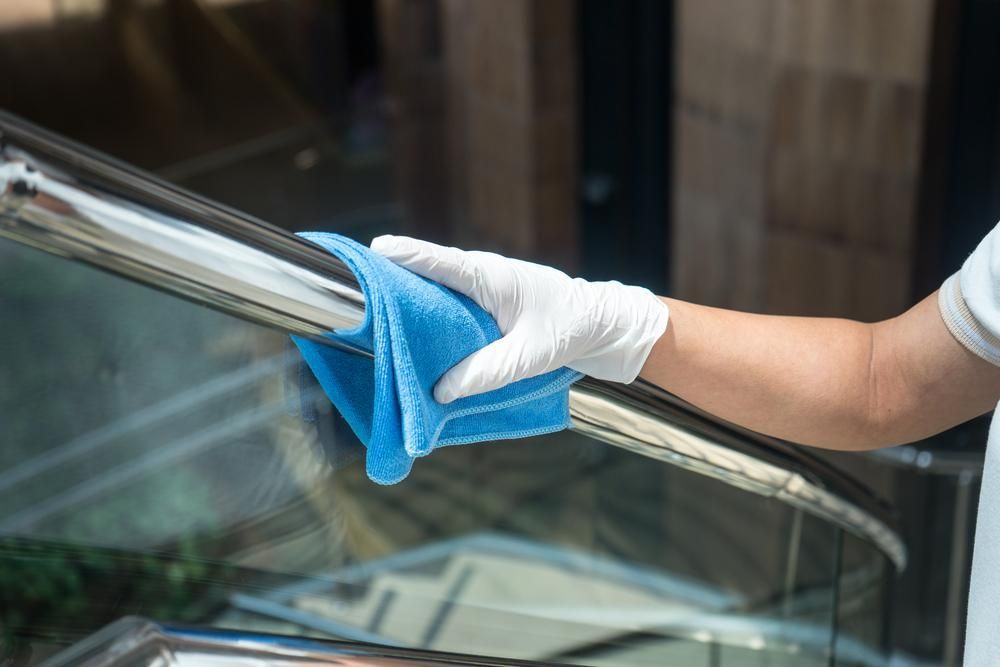 A Person Wearing White Gloves Is Cleaning a Balustrade — KJ's Elite Cleaning Services Newcastle in Newcastle, NSW
