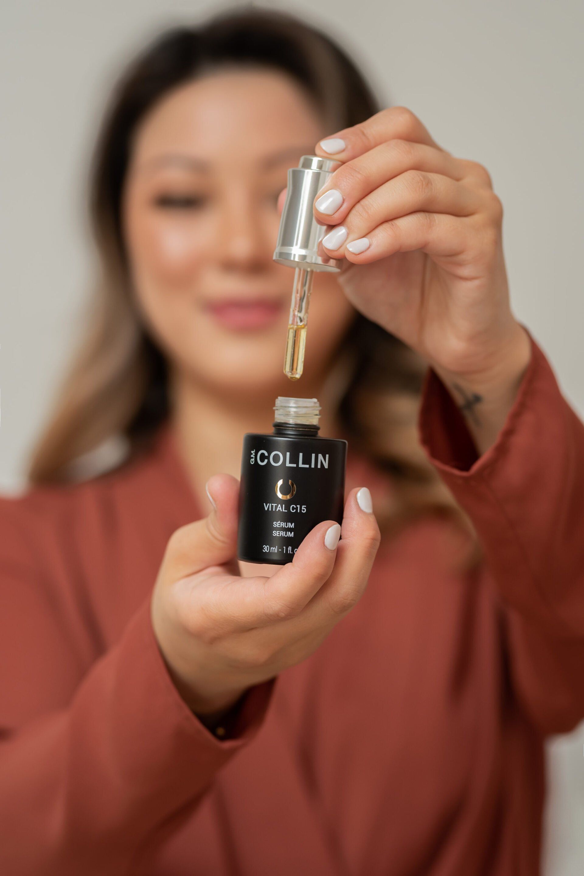 Woman holding a skincare serum product bottle for branding photo