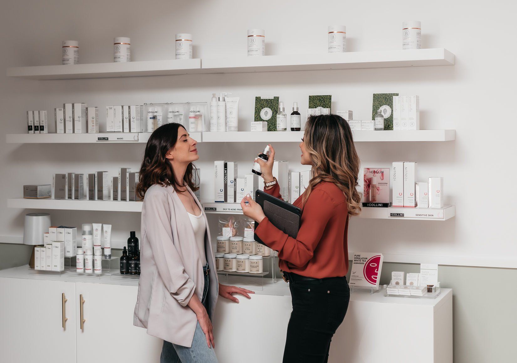 A female beauty advisor spraying a skincare product on a female client's face