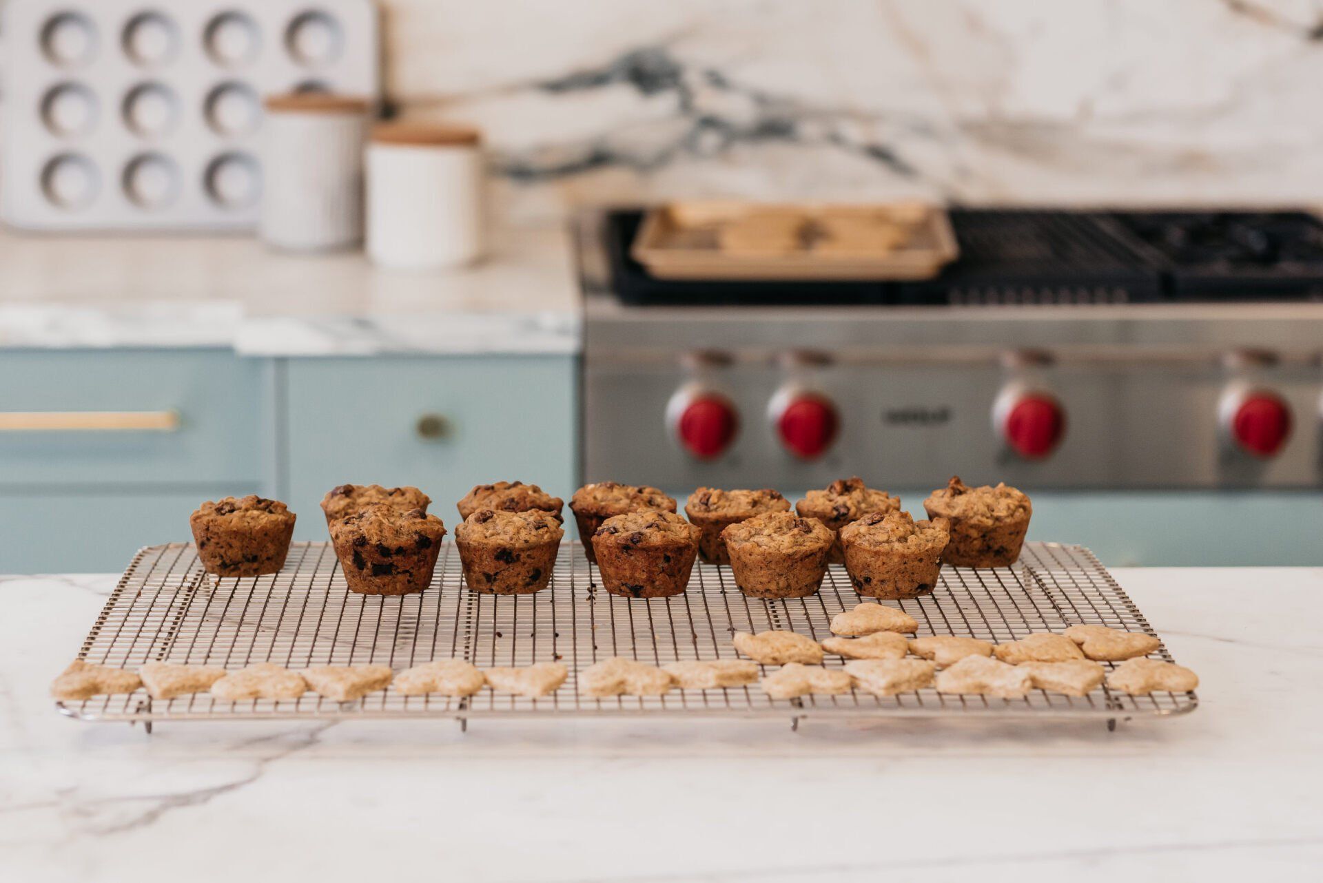 A tray of freshly baked muffins and cookies on top of an elegant marble kitchen counter