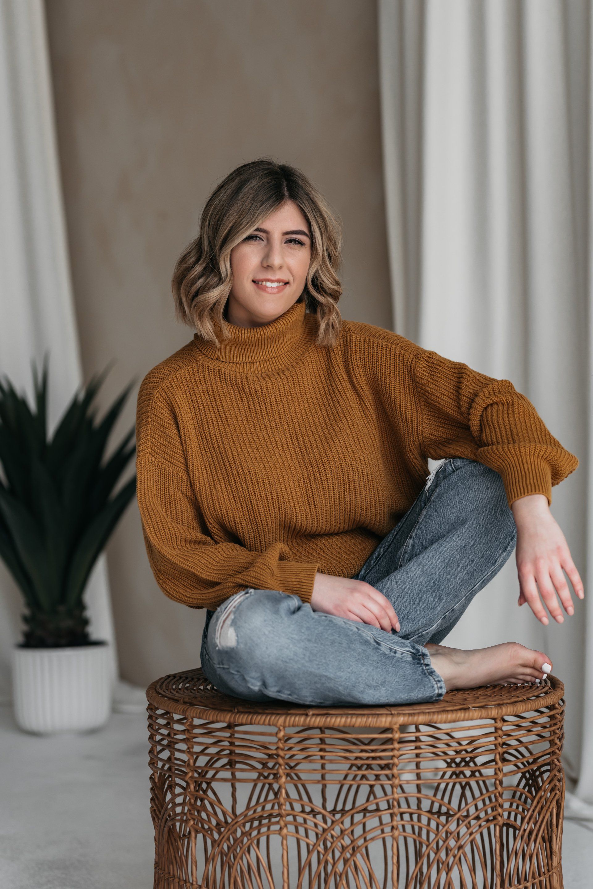 Smiling small business owner sitting on a wicker stool