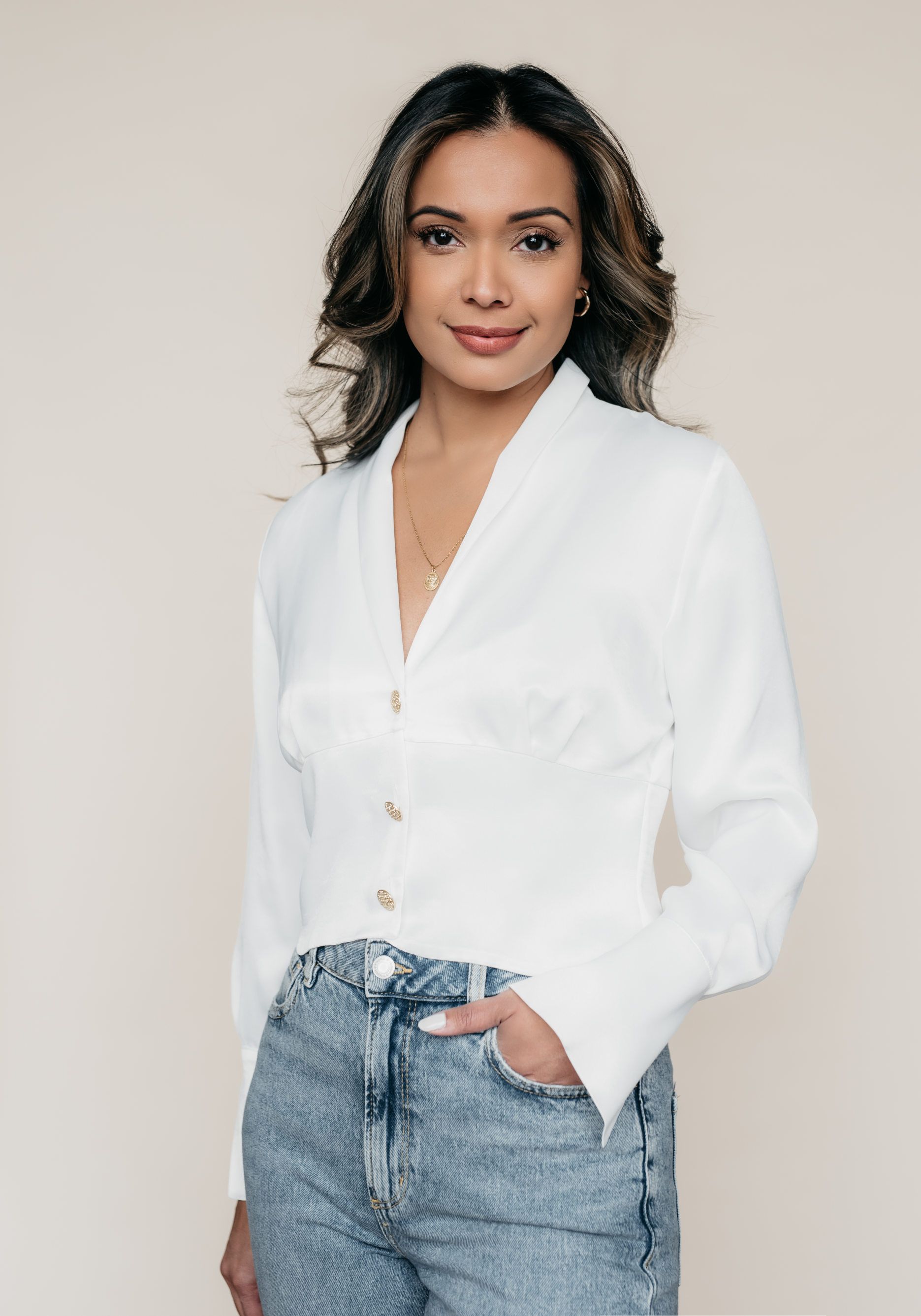 A woman is wearing a white shirt and blue jeans.