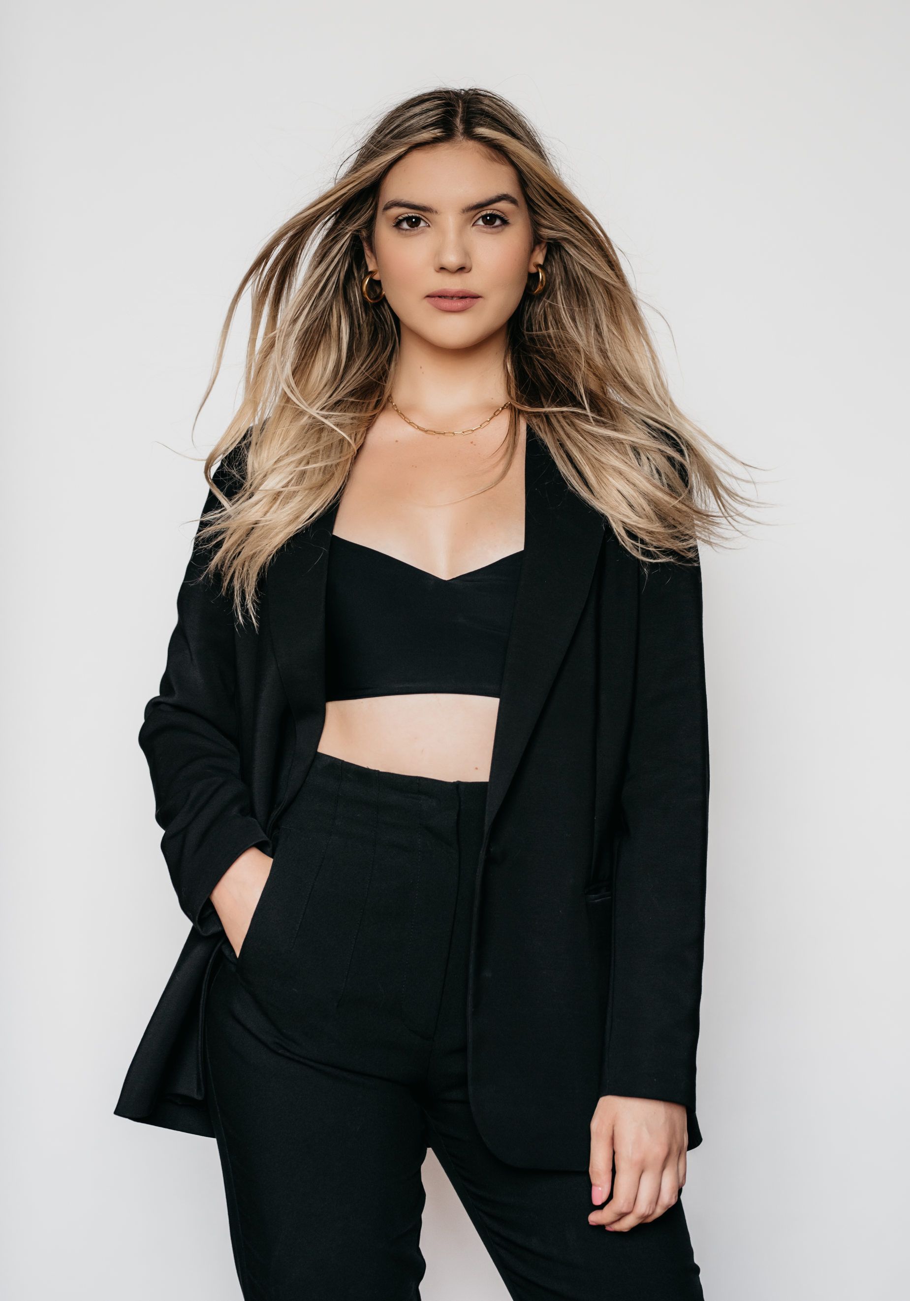 A woman wearing a black blazer and crop top for Toronto headshots.