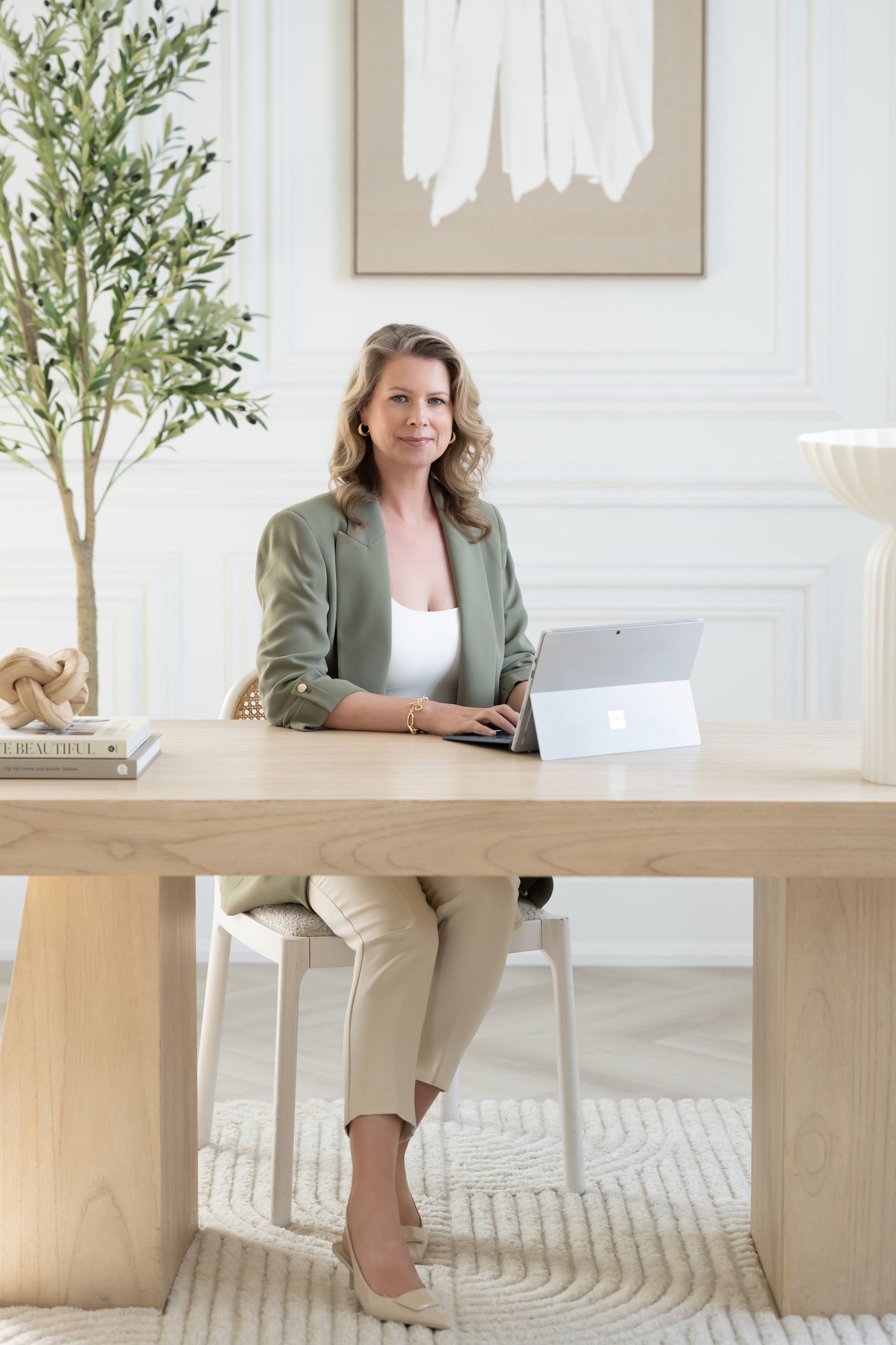 A woman is sitting at a desk with a laptop.