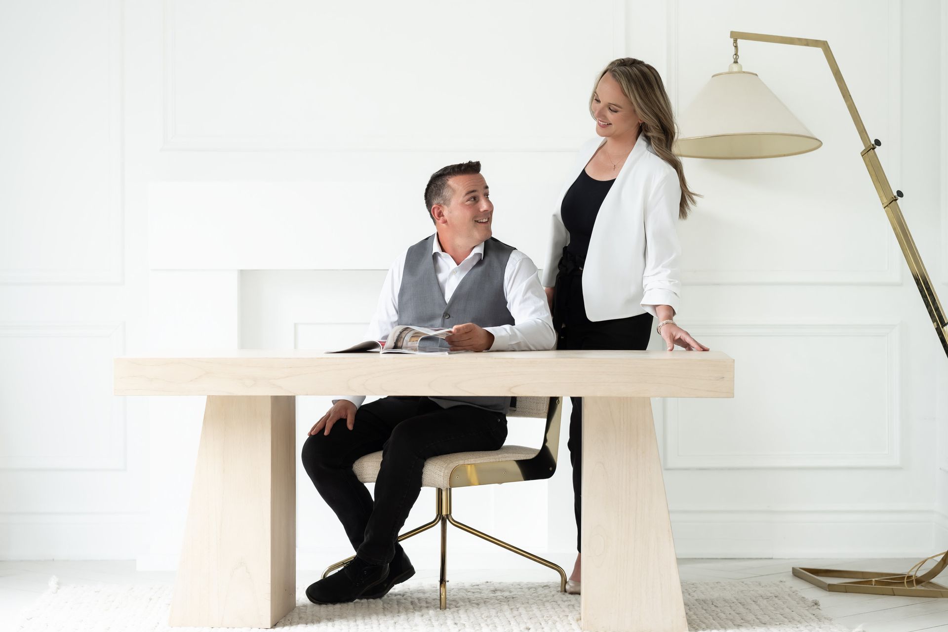 A professional man and woman confidently engaging with each other in a modern office setting, with a focus on their connection and the man's candid expression.