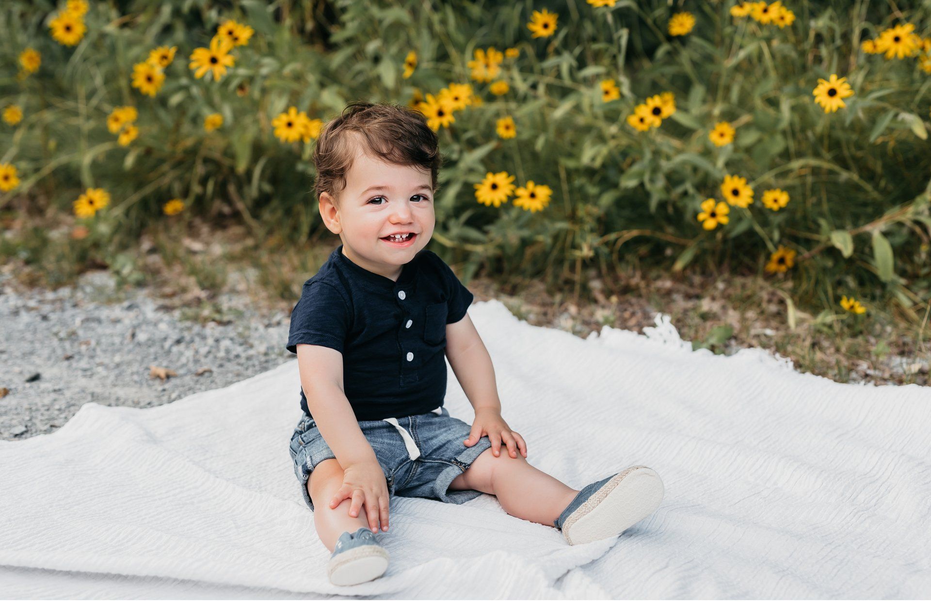 Photo of a smiling toddler sitting on a blanket for unique experience gift