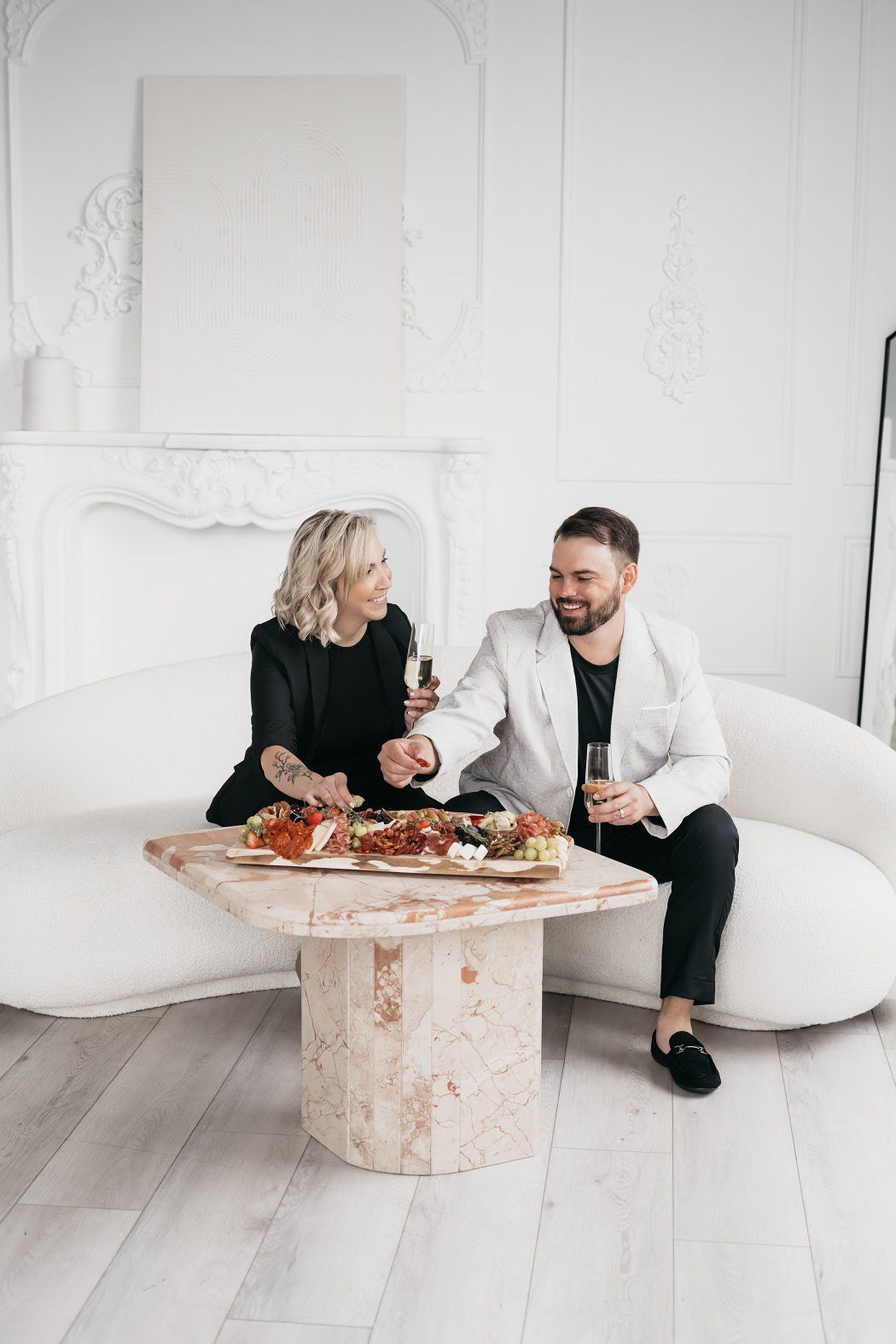 A couple enjoys a meal together while sitting on a cozy couch, surrounded by a relaxed atmosphere.