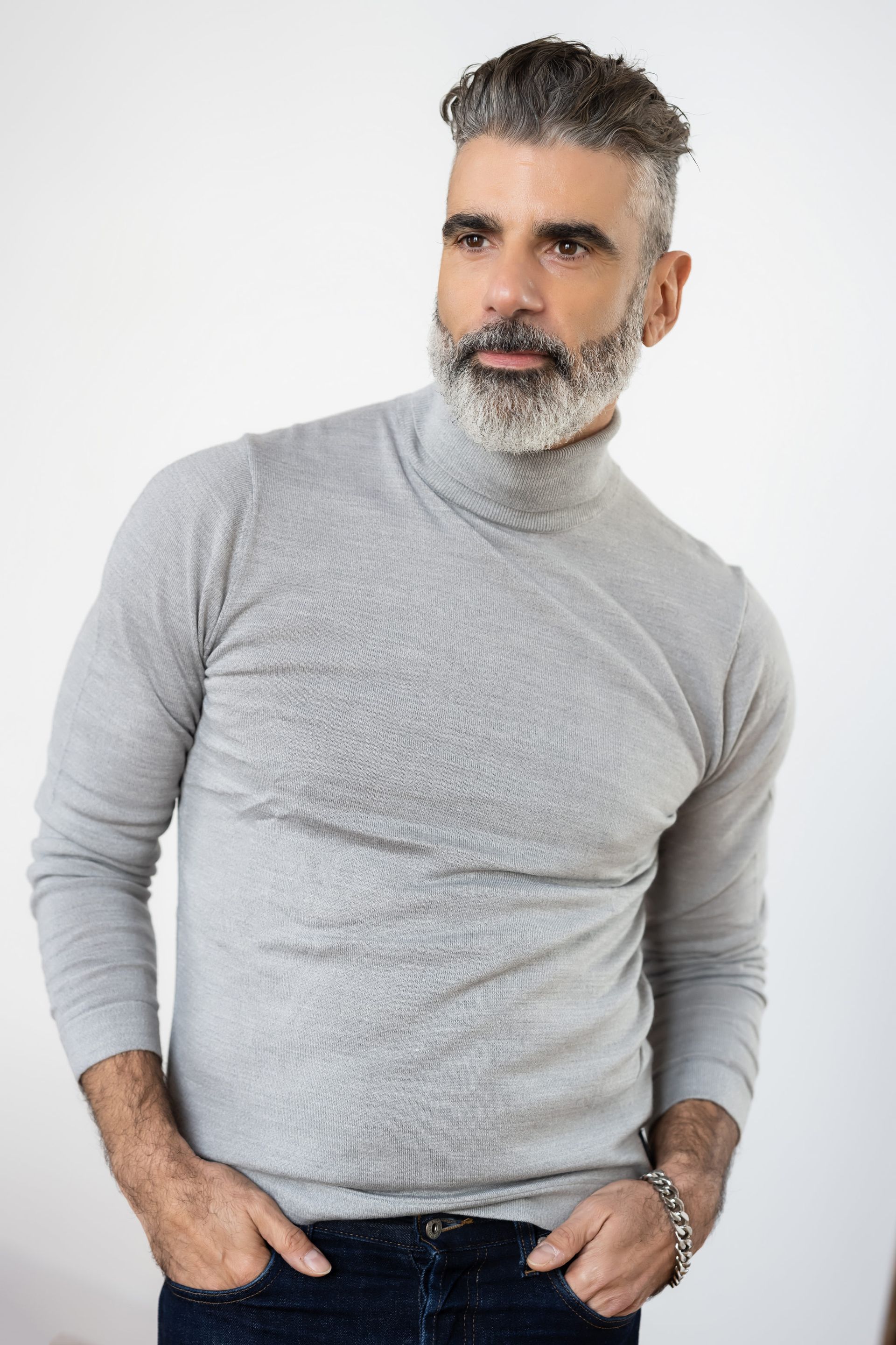Headshot of stylish bearded gentleman wearing a sophisticated gray turtleneck