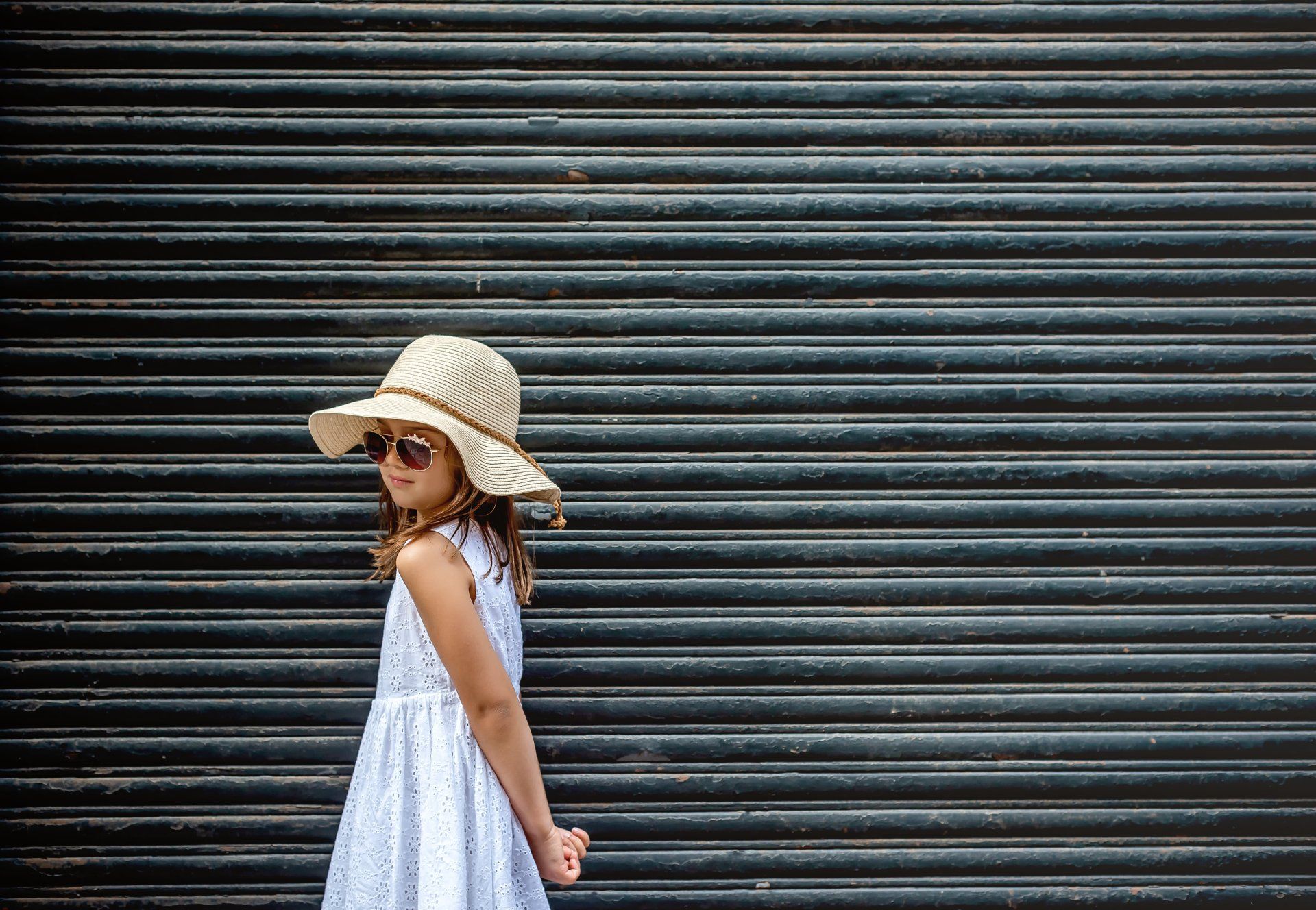 Young girl wearing hat in front of large door |  Child photography | Stacey Naglie Toronto