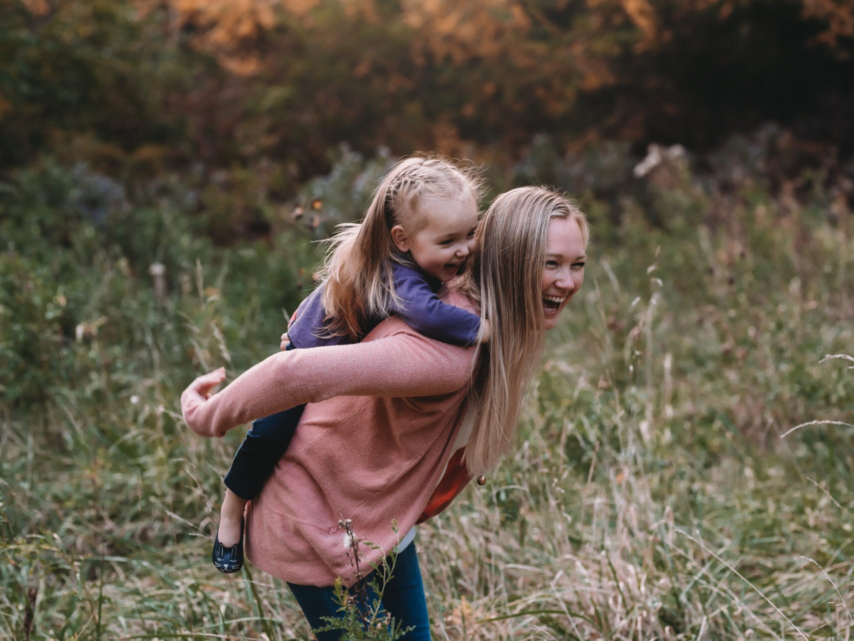 Photo of a girl giving her younger sister a piggy back ride for fun family photography