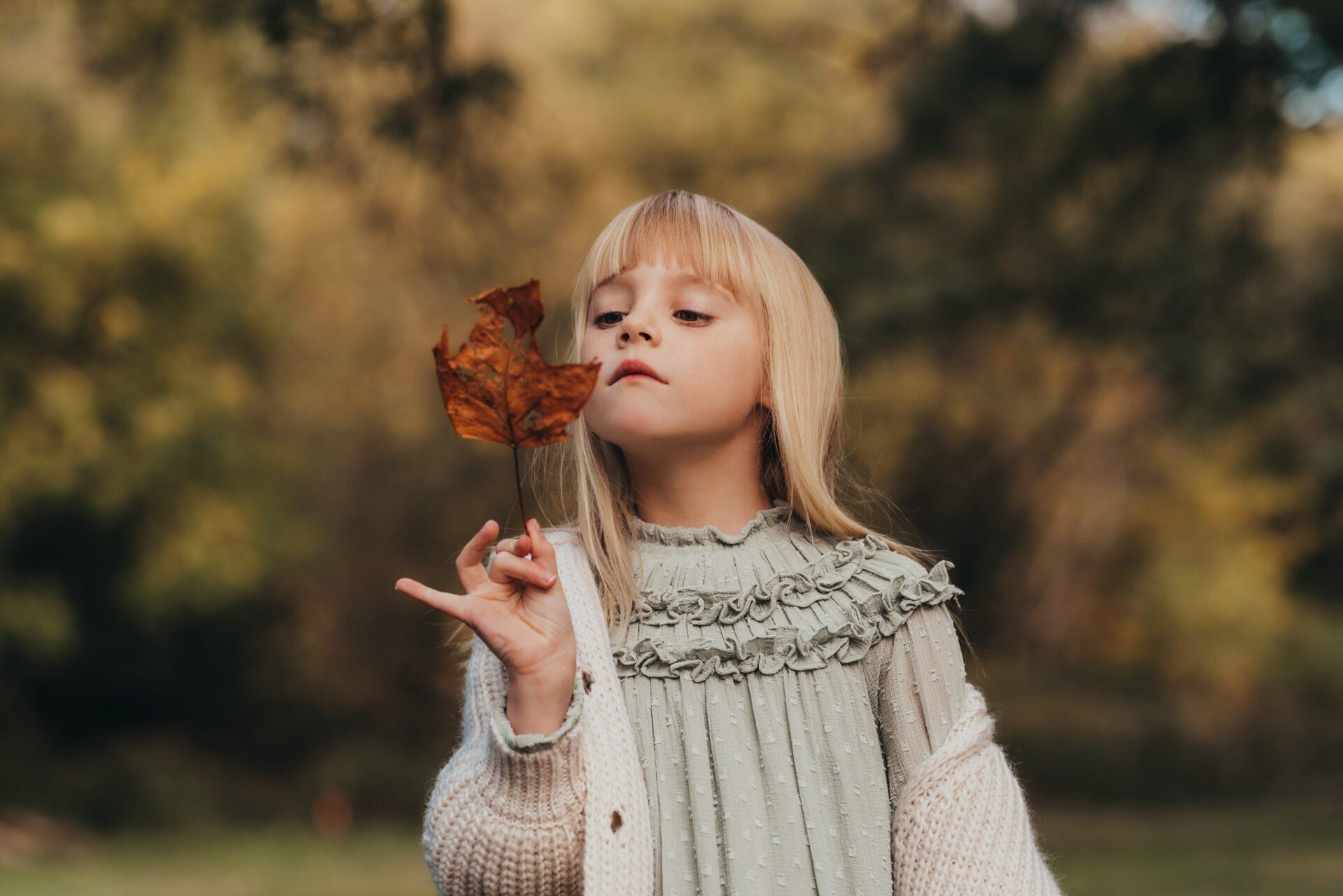 Photo of small girl holding a leaf for family photography