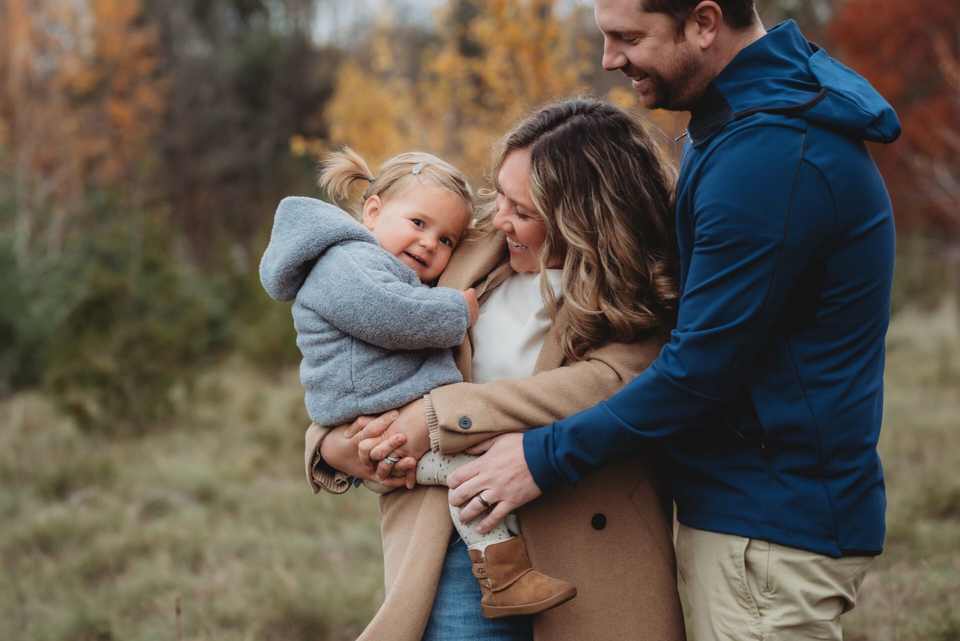 Photo of parents holding toddler while embraced for family photography