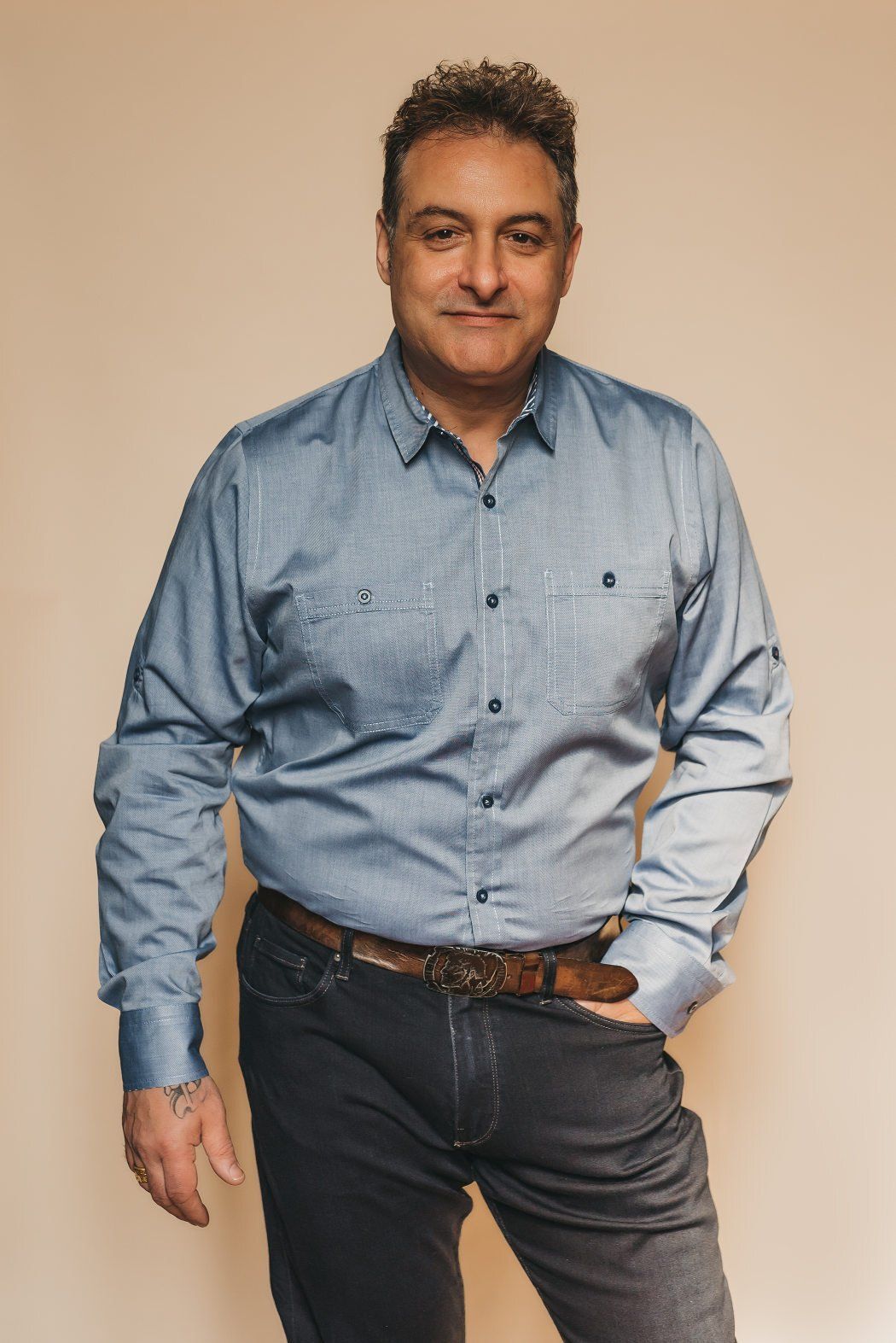 A male business owner standing with one hand in front jean pocket in a professional headshot photograph