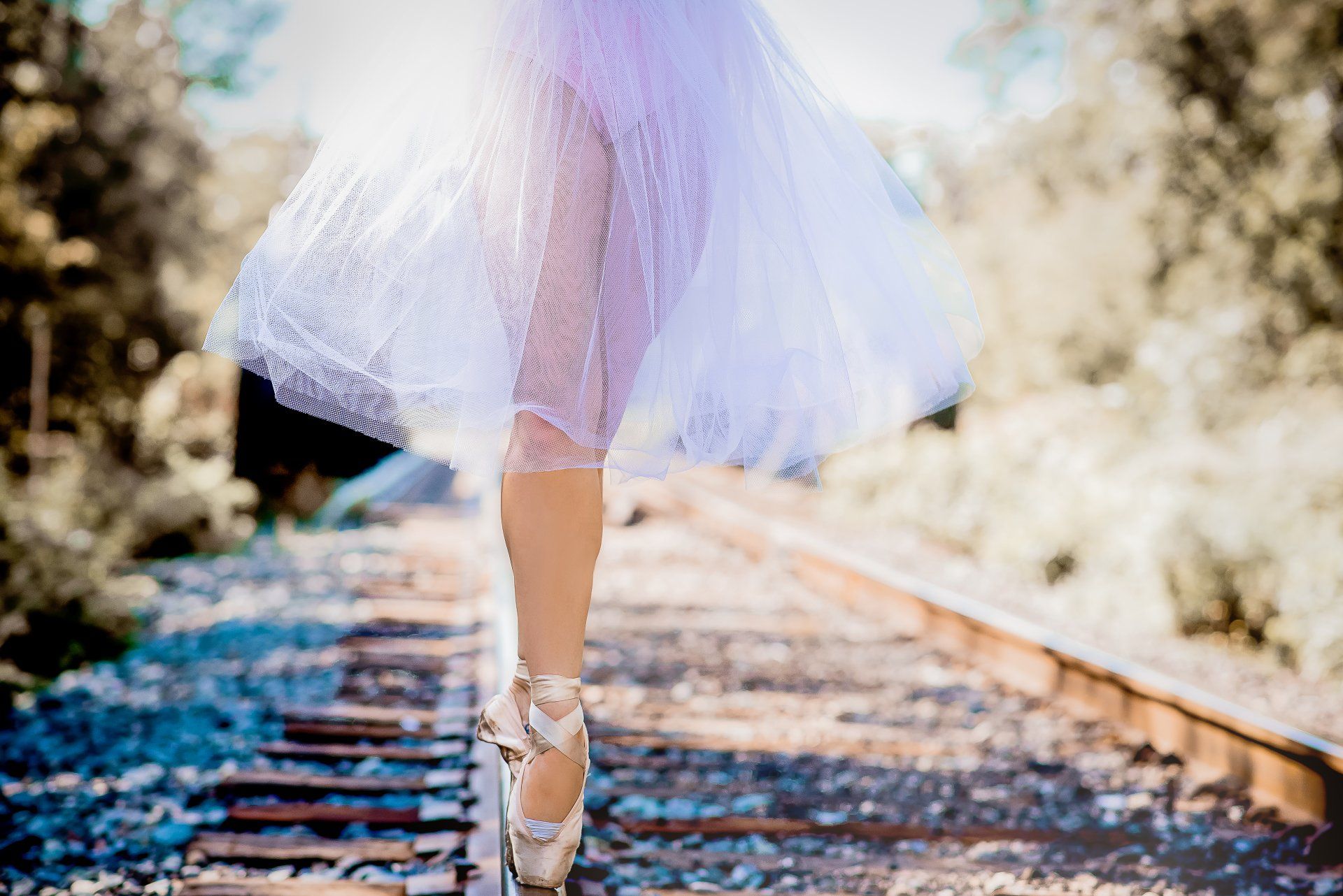 Photo of the lower half of ballet dancer dancing en pointe on a road track