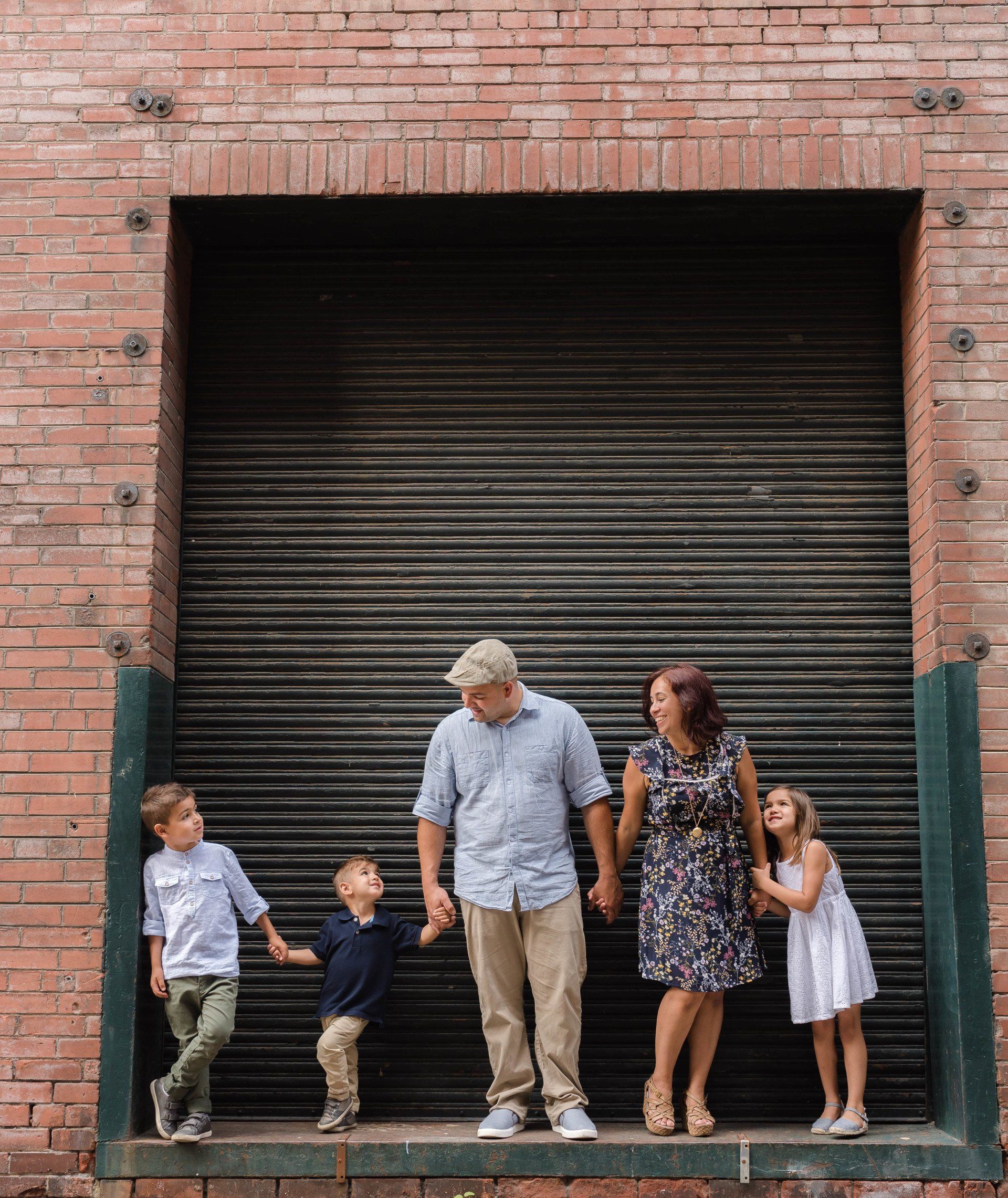 Photography of a family holding hands in front of large garage door