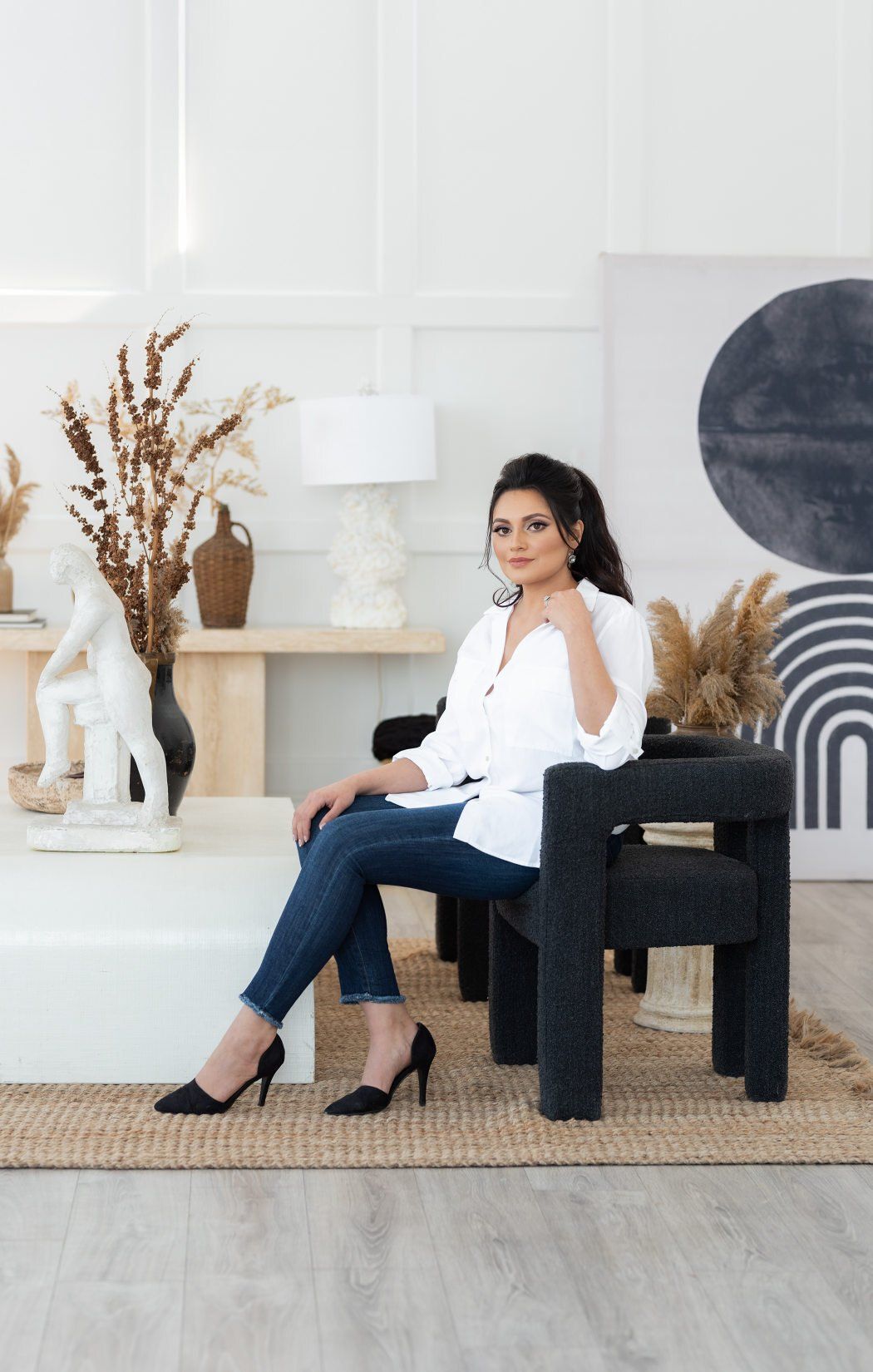 Personal branding photo of a woman with white blouse sitting in a chair