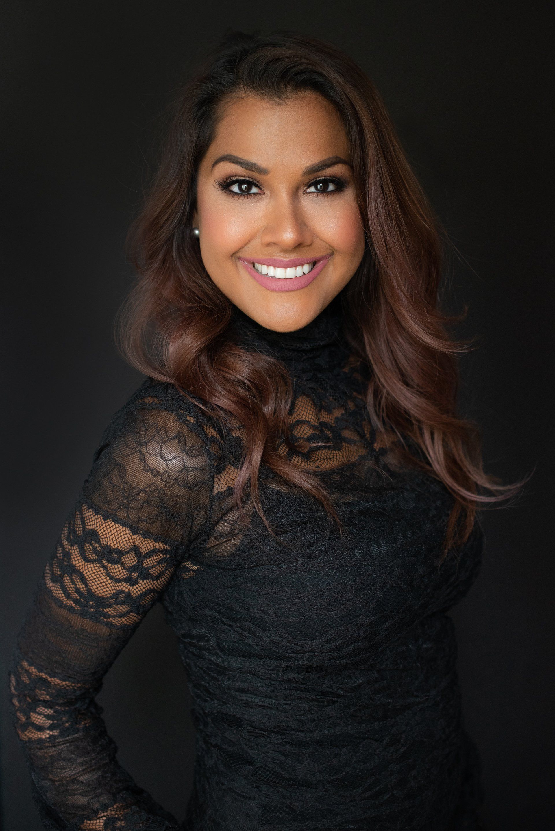 a photograph of a smiling woman wearing black dress