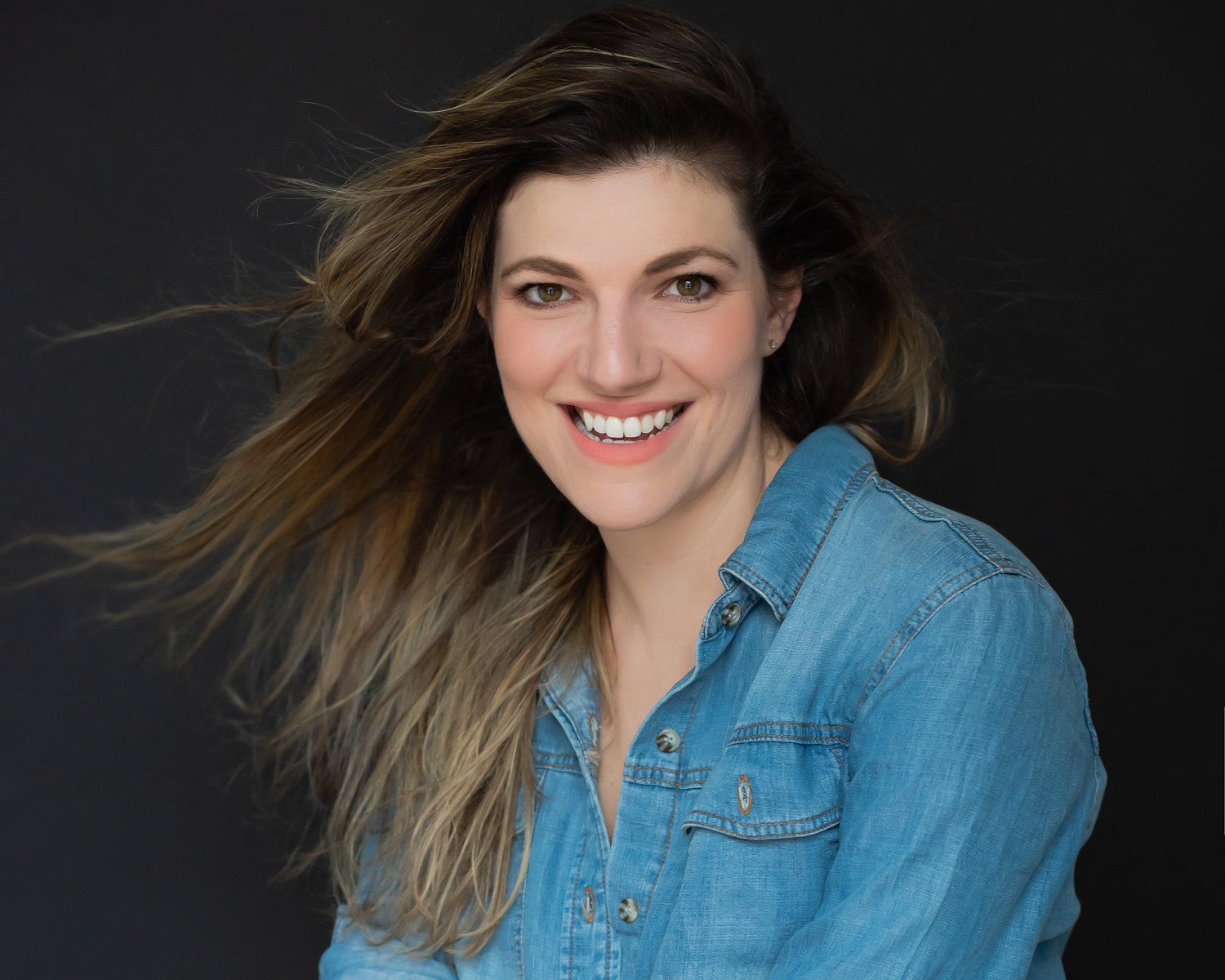 Professional Portrait Photography | Stacey Naglie Toronto  | Smiling woman in blue top in front of dark wall