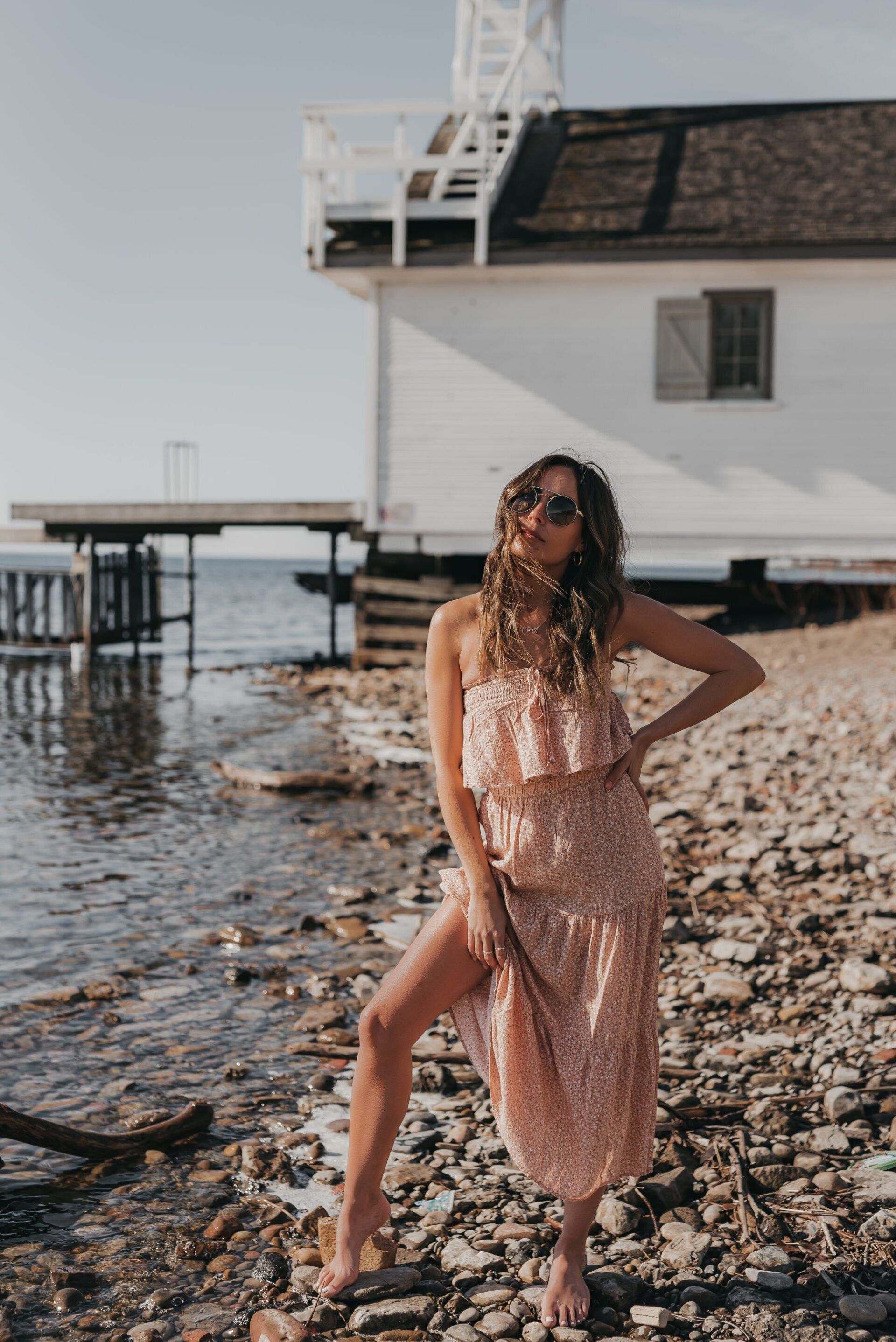 a woman at the beach wearing a peach summer dress with ruffles