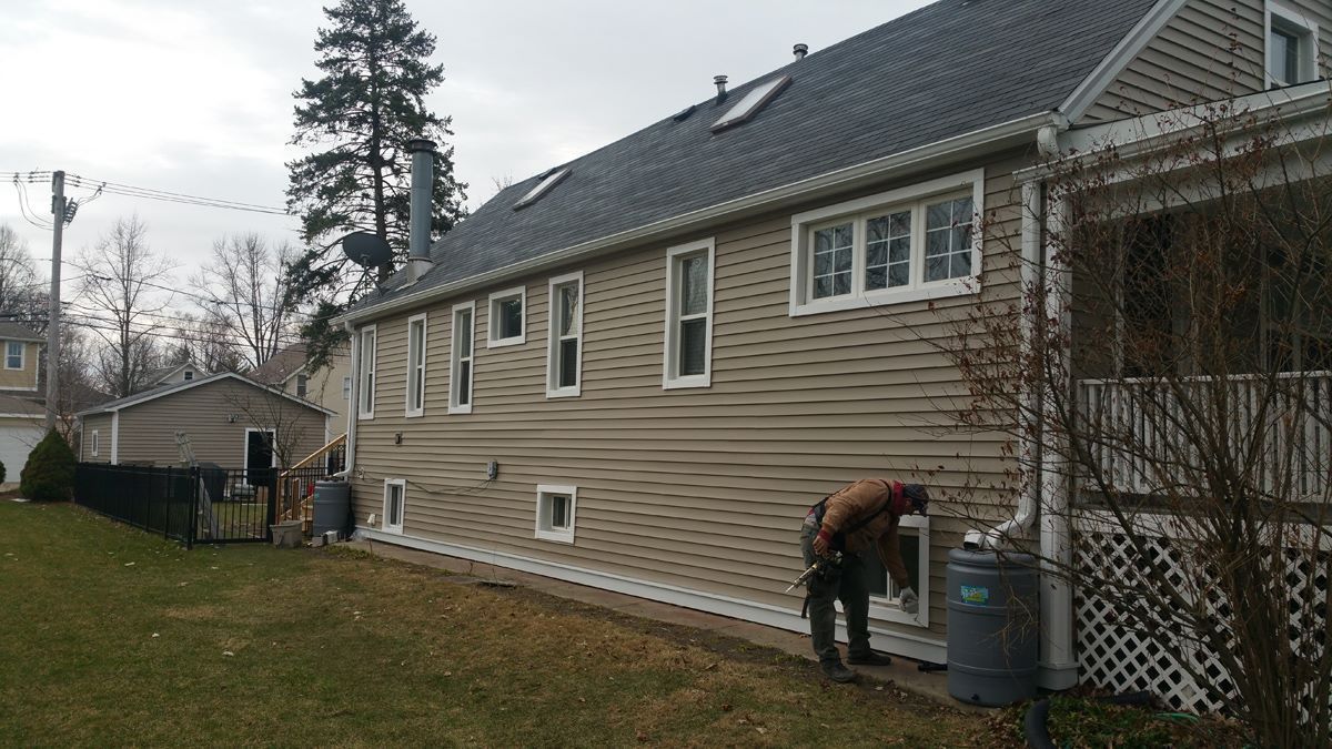 A man is working on the side of a house.