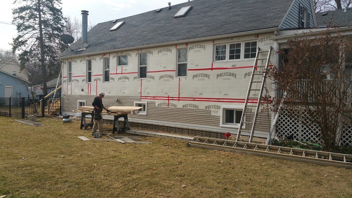 A man is working on the side of a house.