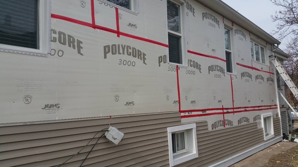 A house is being remodeled with a new siding and windows.