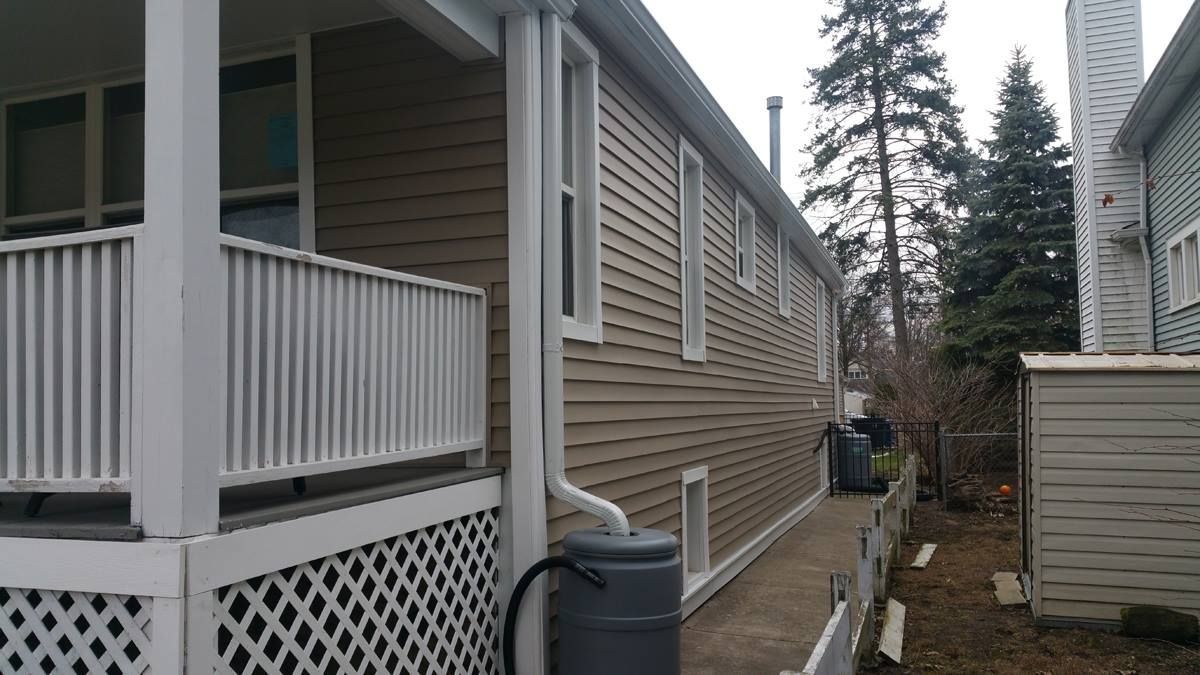 A house with a porch and a gutter on the side