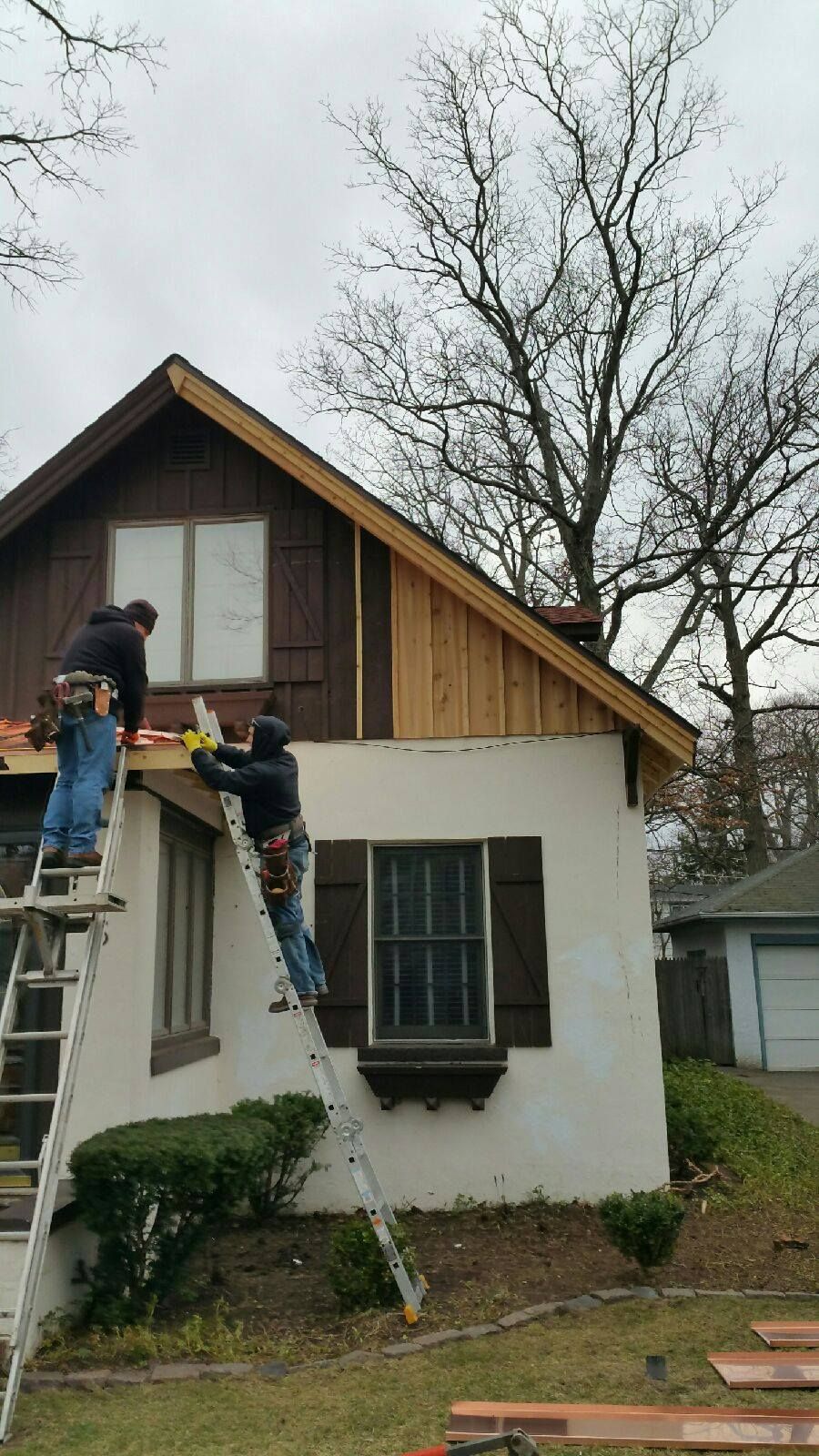 A group of men are working on the roof of a house.