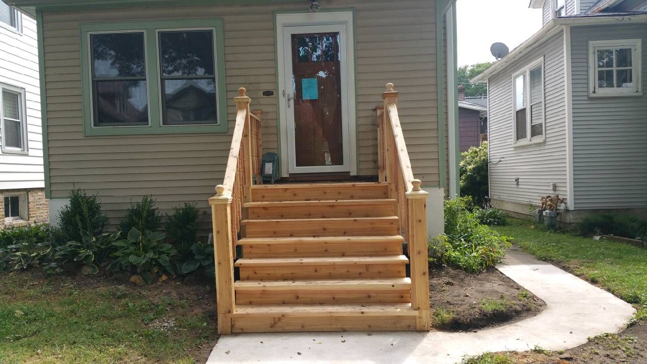A house with wooden stairs leading up to the front door.