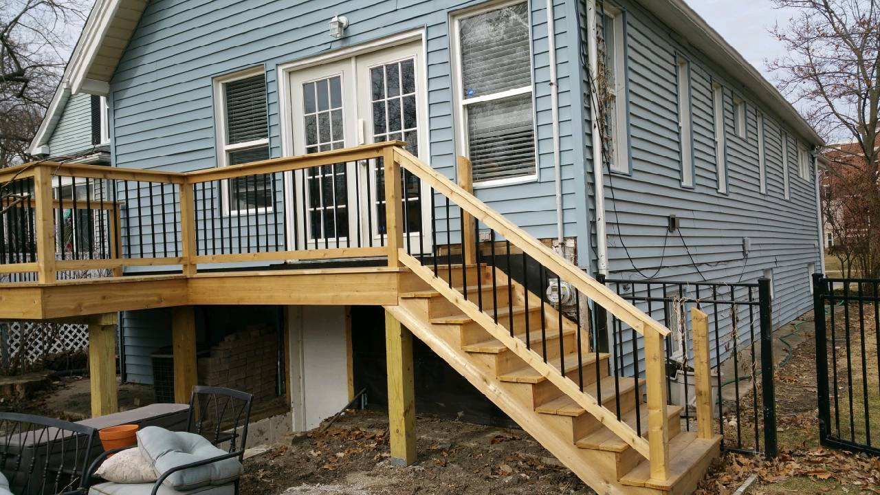 A blue house with a wooden deck and stairs