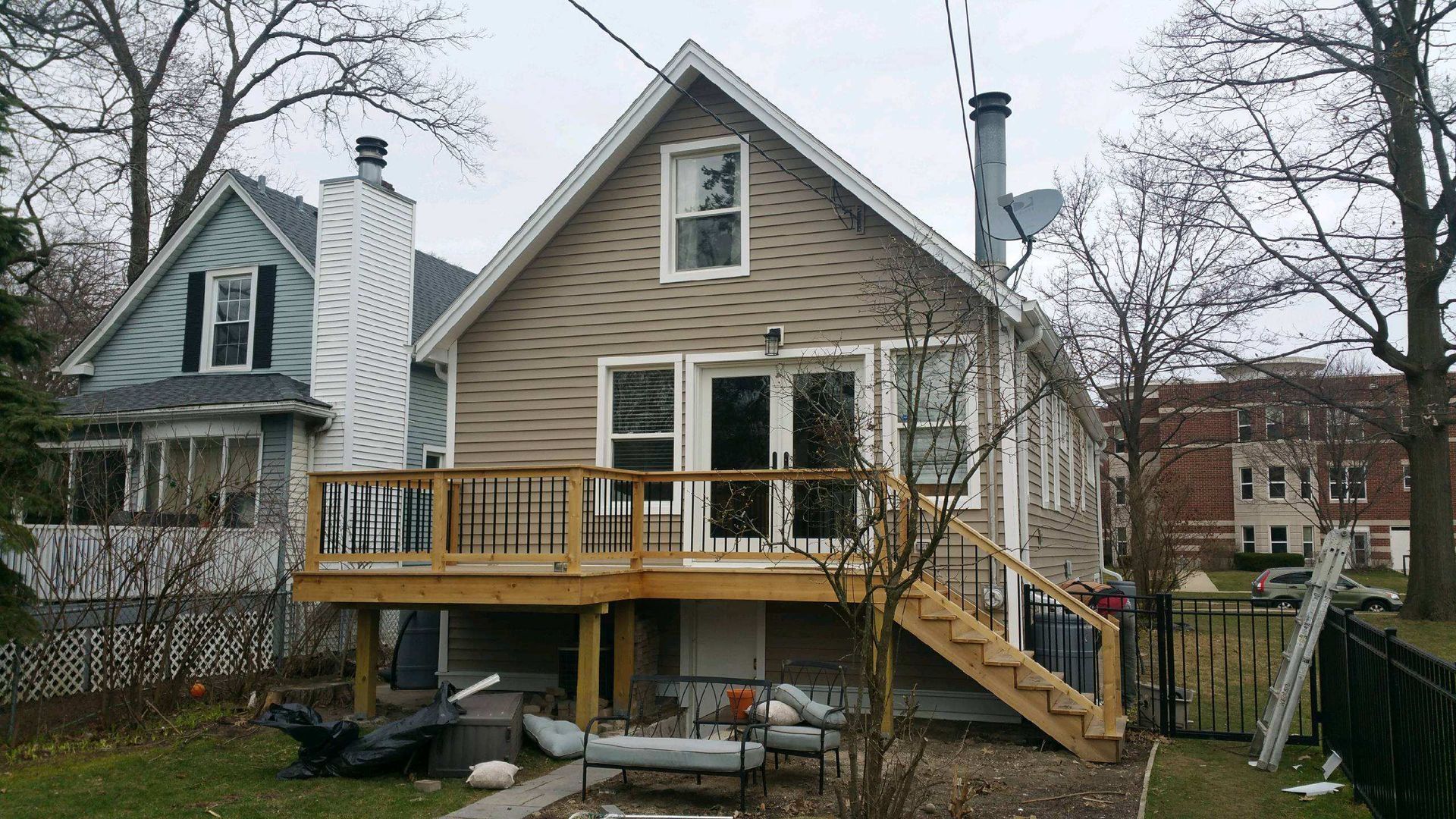 The back of a house with a wooden deck and stairs.