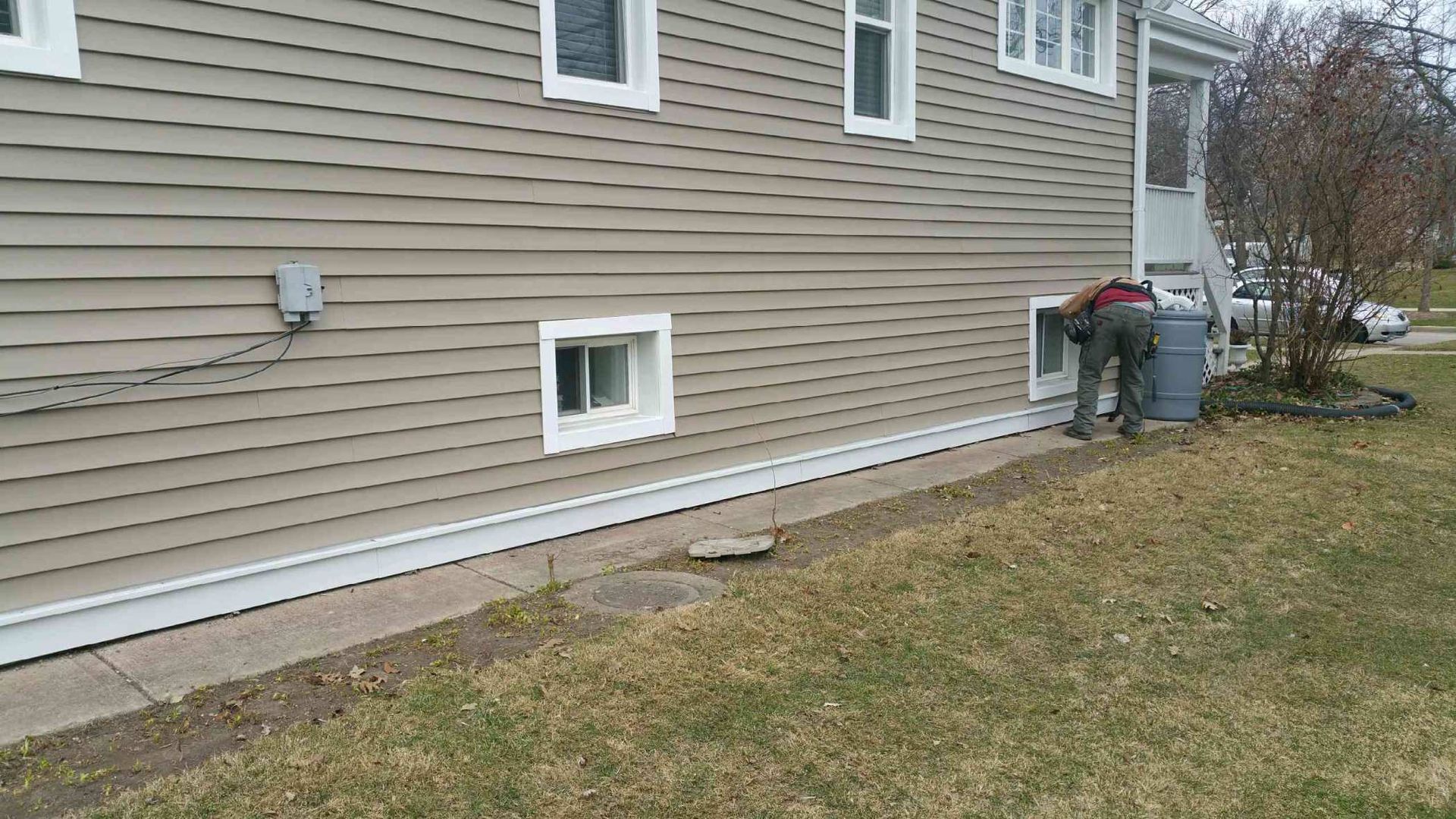 A man is working on the side of a house.