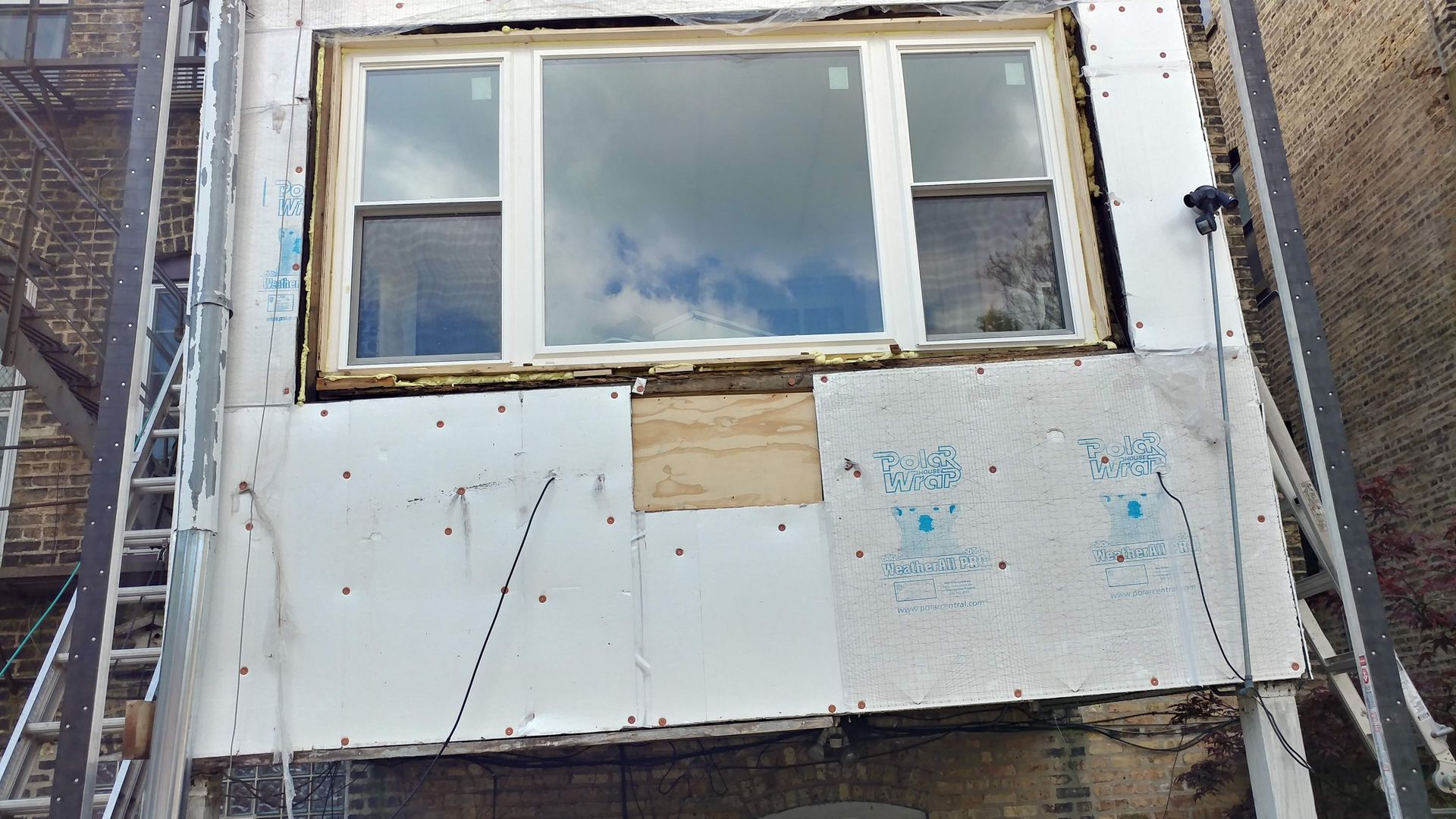 A window on the side of a building that is being remodeled