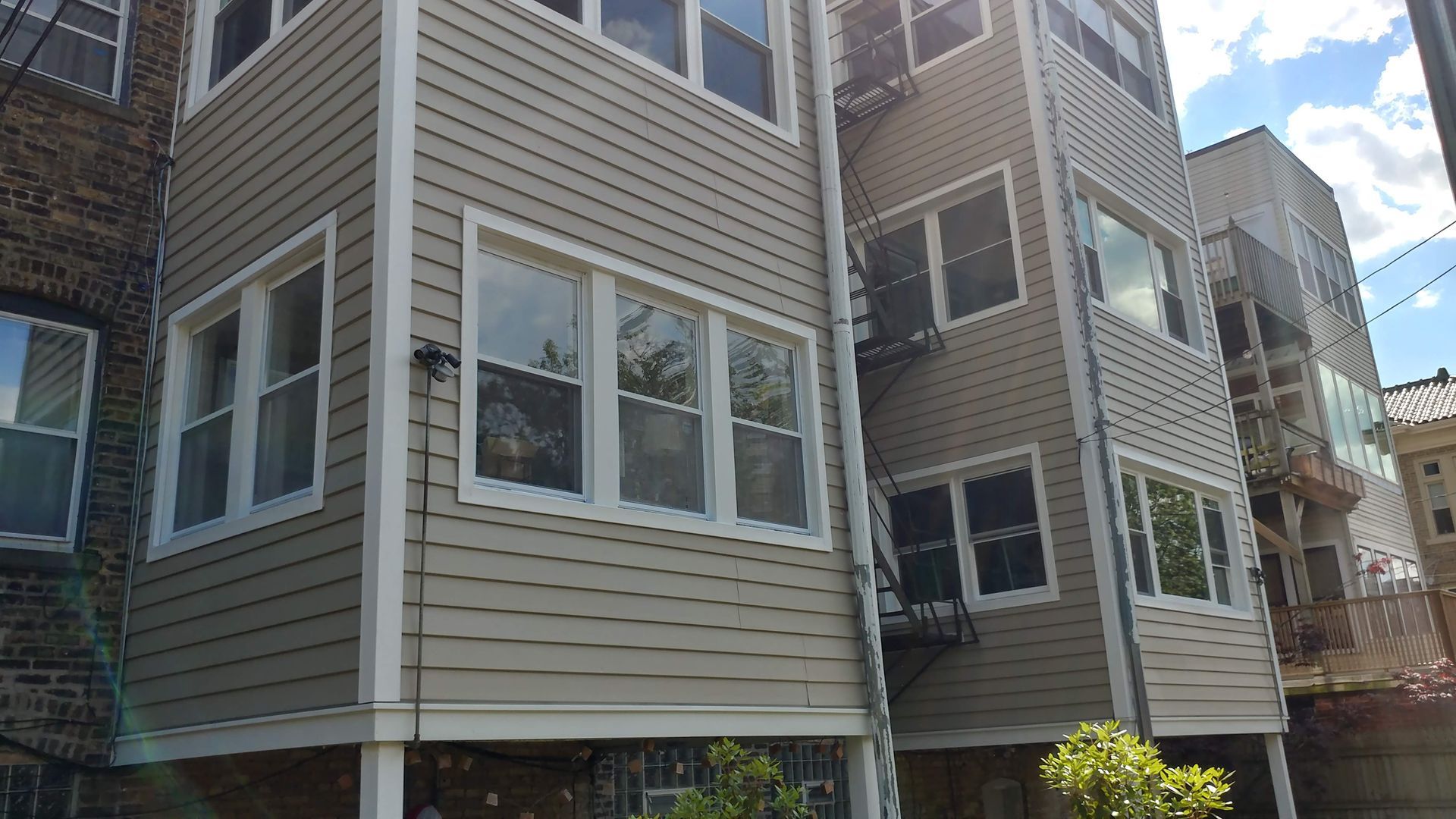 A large apartment building with a lot of windows and a fire escape.