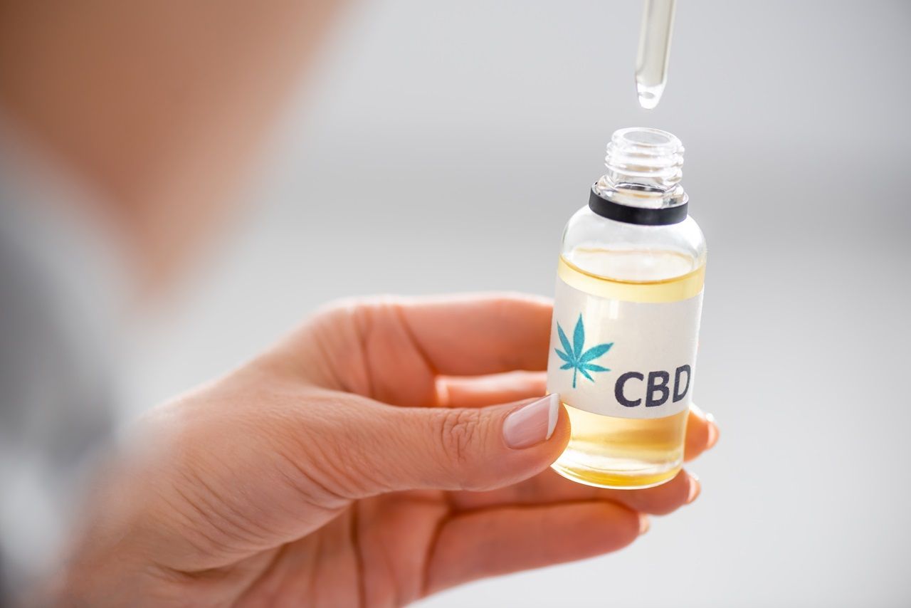 woman holding bottle with cbd 