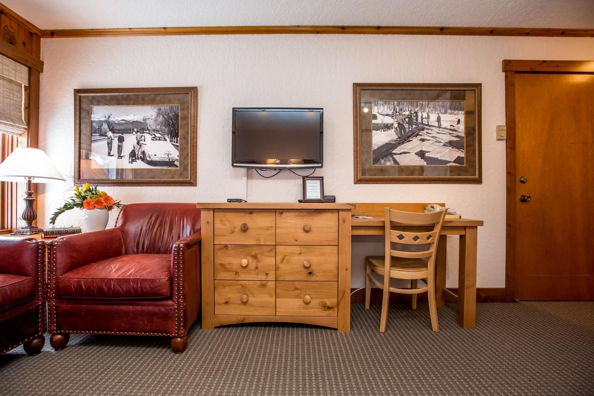 A living room with a couch , chair , desk and television.
