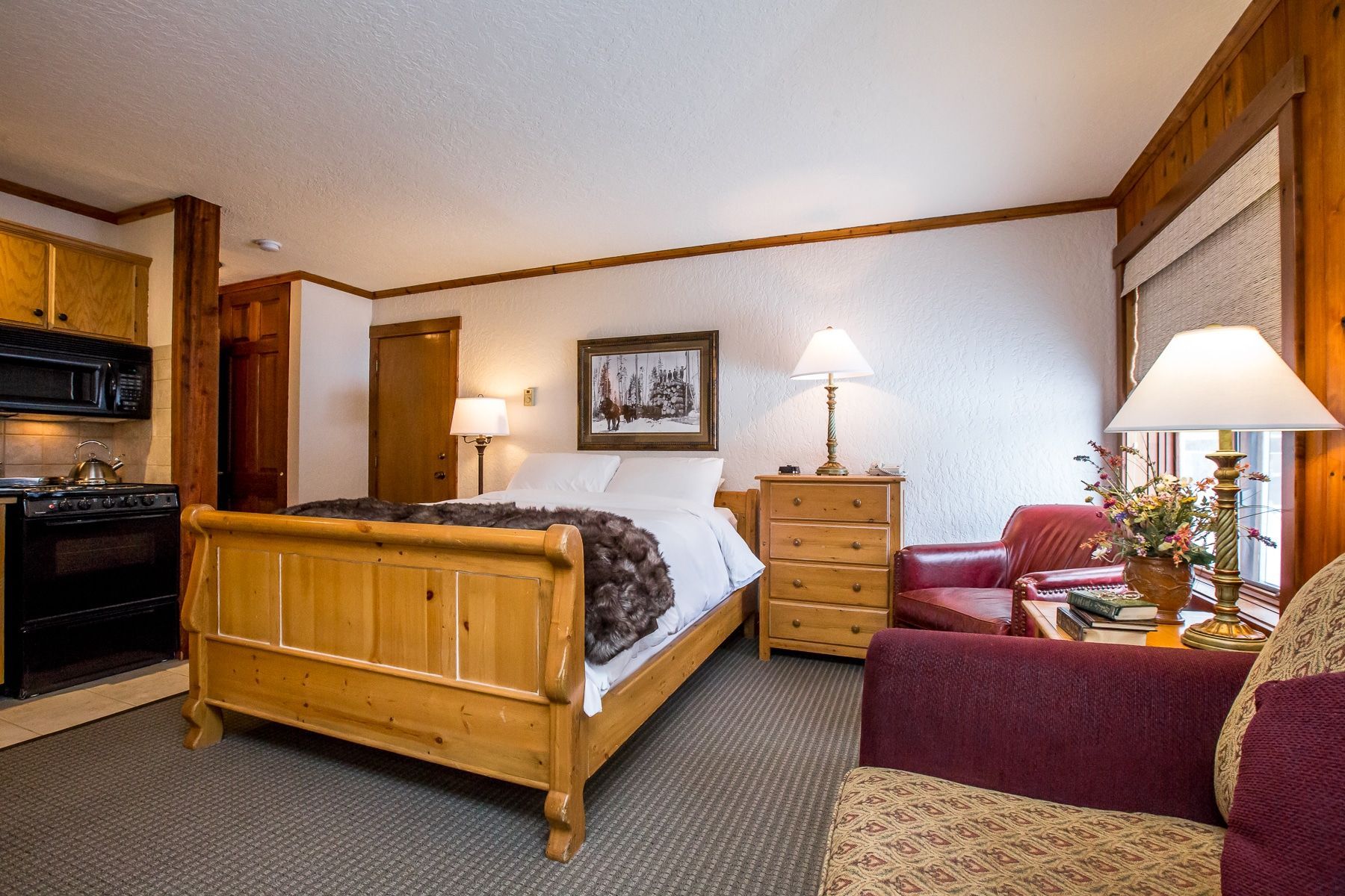 A hotel room with a king size bed and a living room